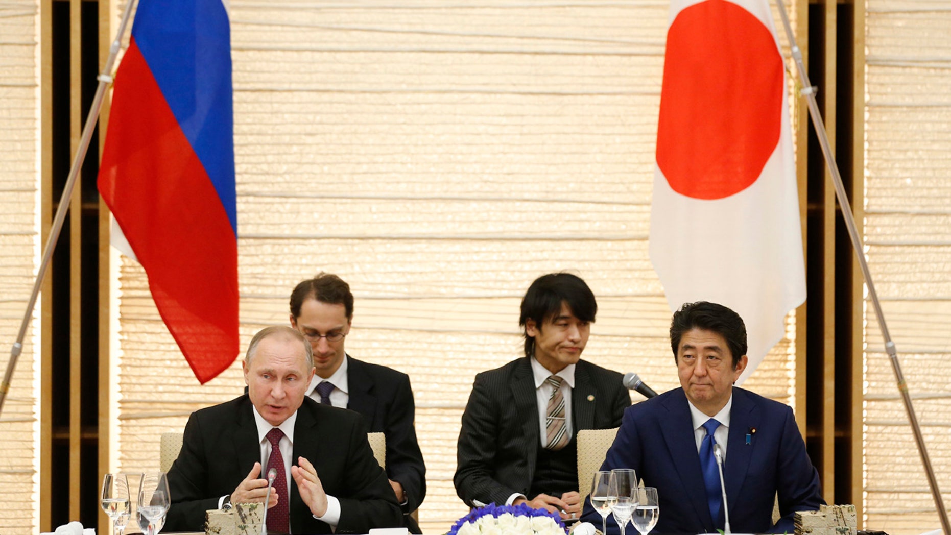 Russian President Vladimir Putin, left, and Japanese Prime Minister Shinzo Abe, right, attend a working lunch in Tokyo, Japan, Friday, Dec. 16, 2016.