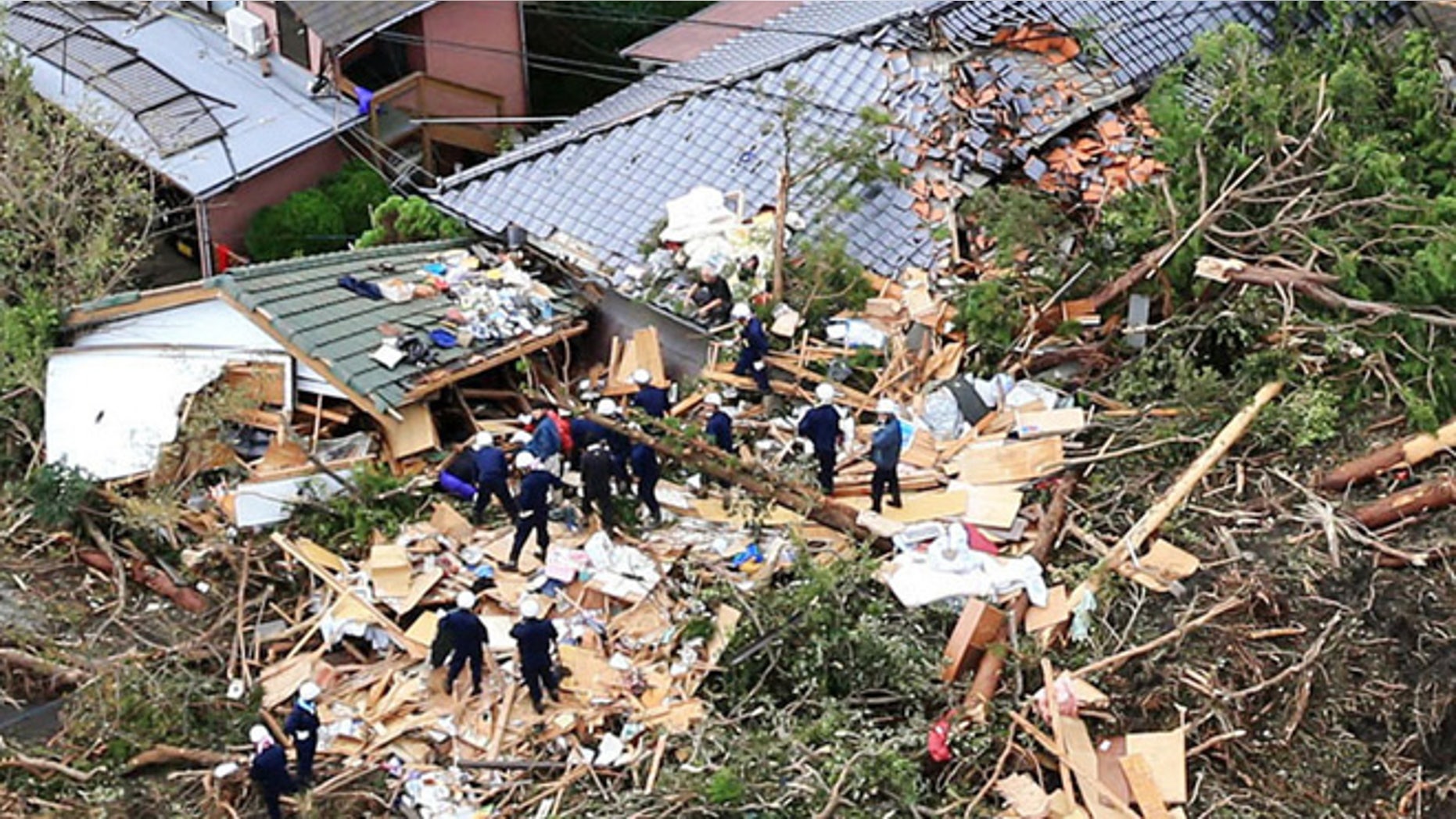 Oct. 16, 2013: Rescue workers look for survivors as they stand on the rubble of a house buried by mudslides after a powerful typhoon hit Oshima on Izu Oshima island, about 75 miles south of Tokyo Wednesday morning.