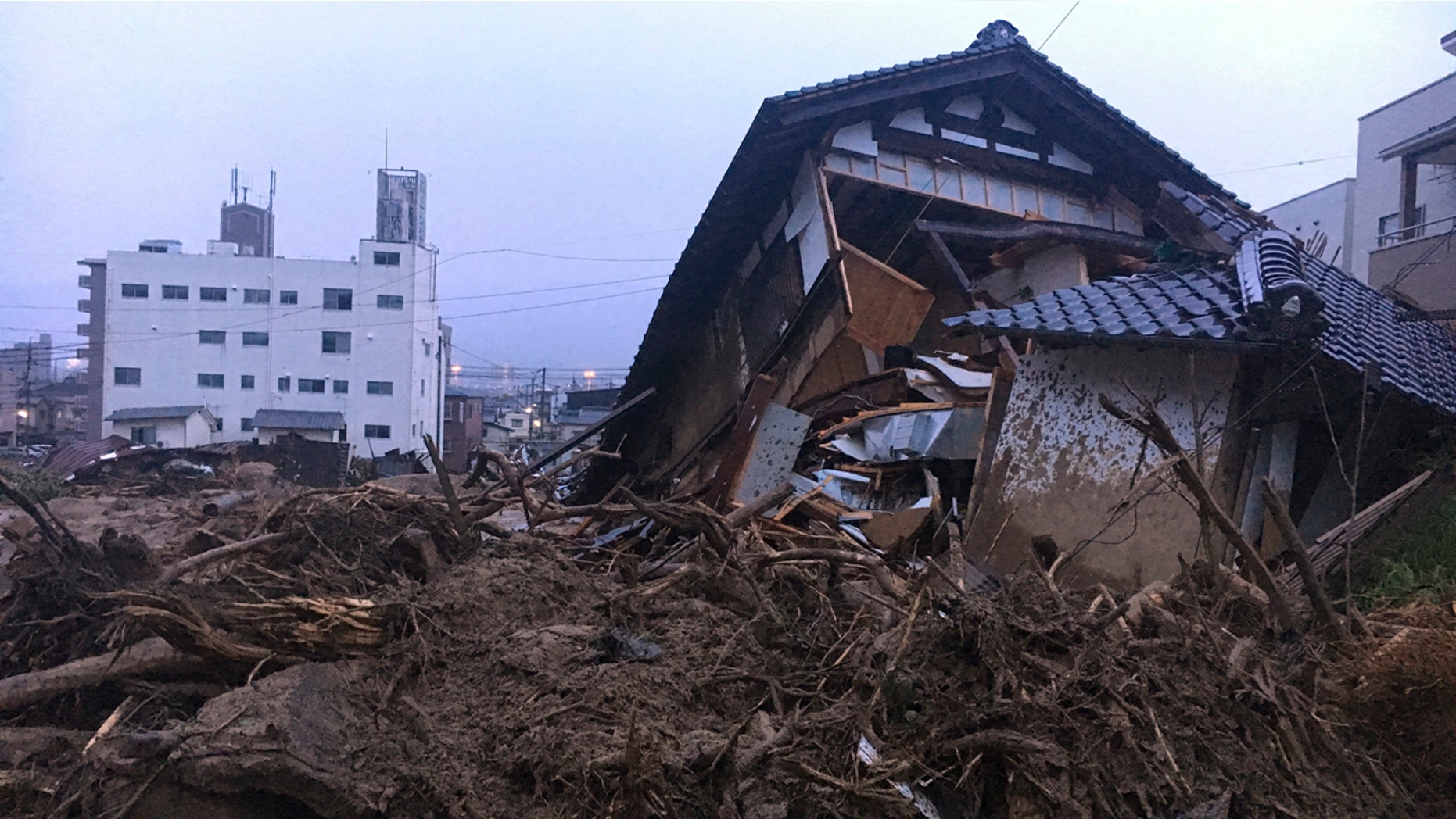 Debris fills a small village following heavy rains Sunday, July 8, 2018, in Kuchita-Minami, Asakita-ku, Hiroshima, Japan. Searches continued Sunday night for dozens of victims still missing from the heavy rainfall that hammered southern Japan for the third straight day. (AP Photo Haruka Nuga)