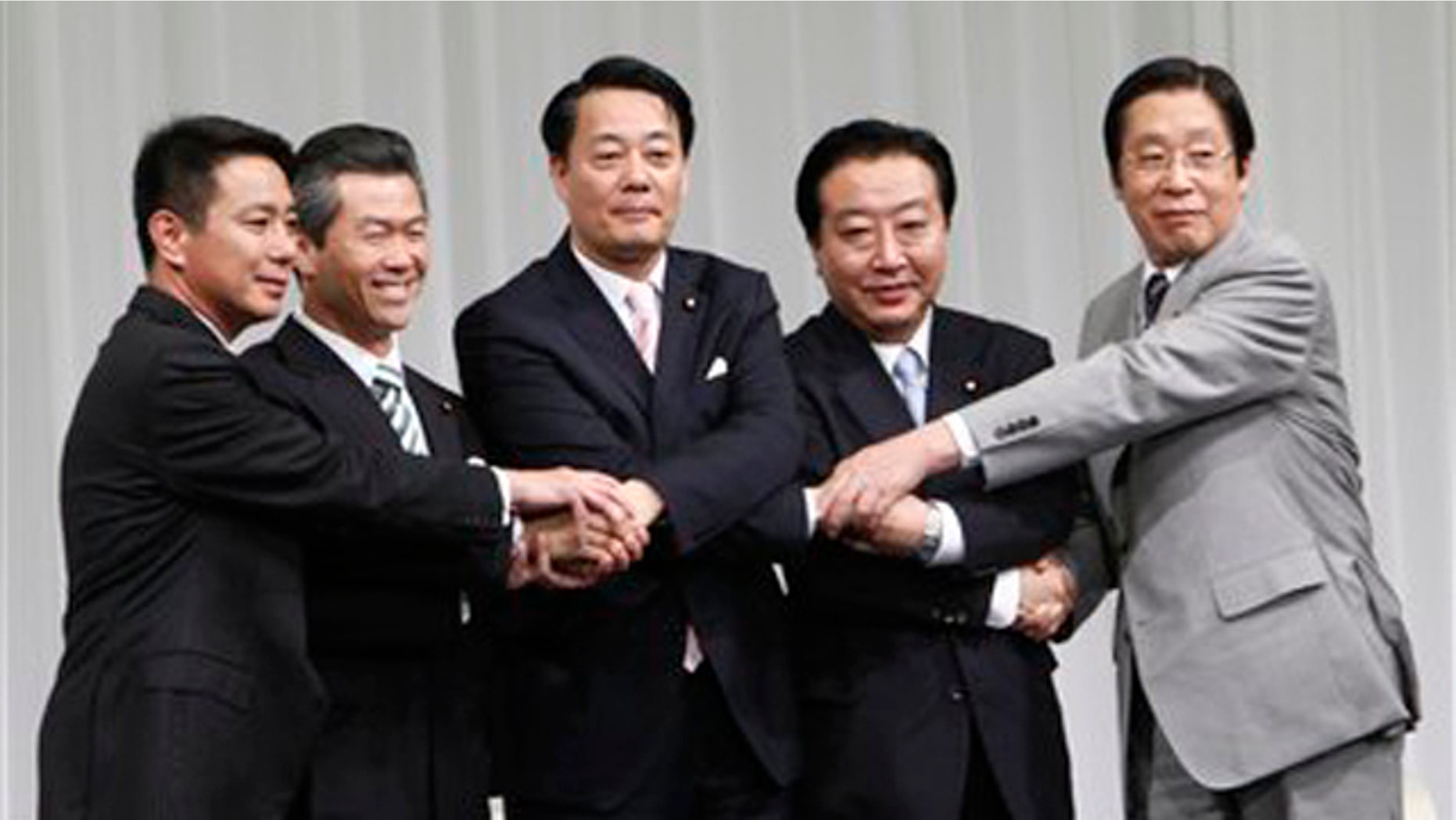 Candidates for the leader of Japan's ruling Democratic Party, from left, former Foreign Minister Seiji Maehara, former Transport Minister Sumio Mabuchi, Trade and Economy Minister Banri Kaieda, Finance Minister Yoshihiko Noda and Farm Minister Michihiko Kano, join their hands prior to a debate in Tokyo Sunday, Aug. 28, 2011.