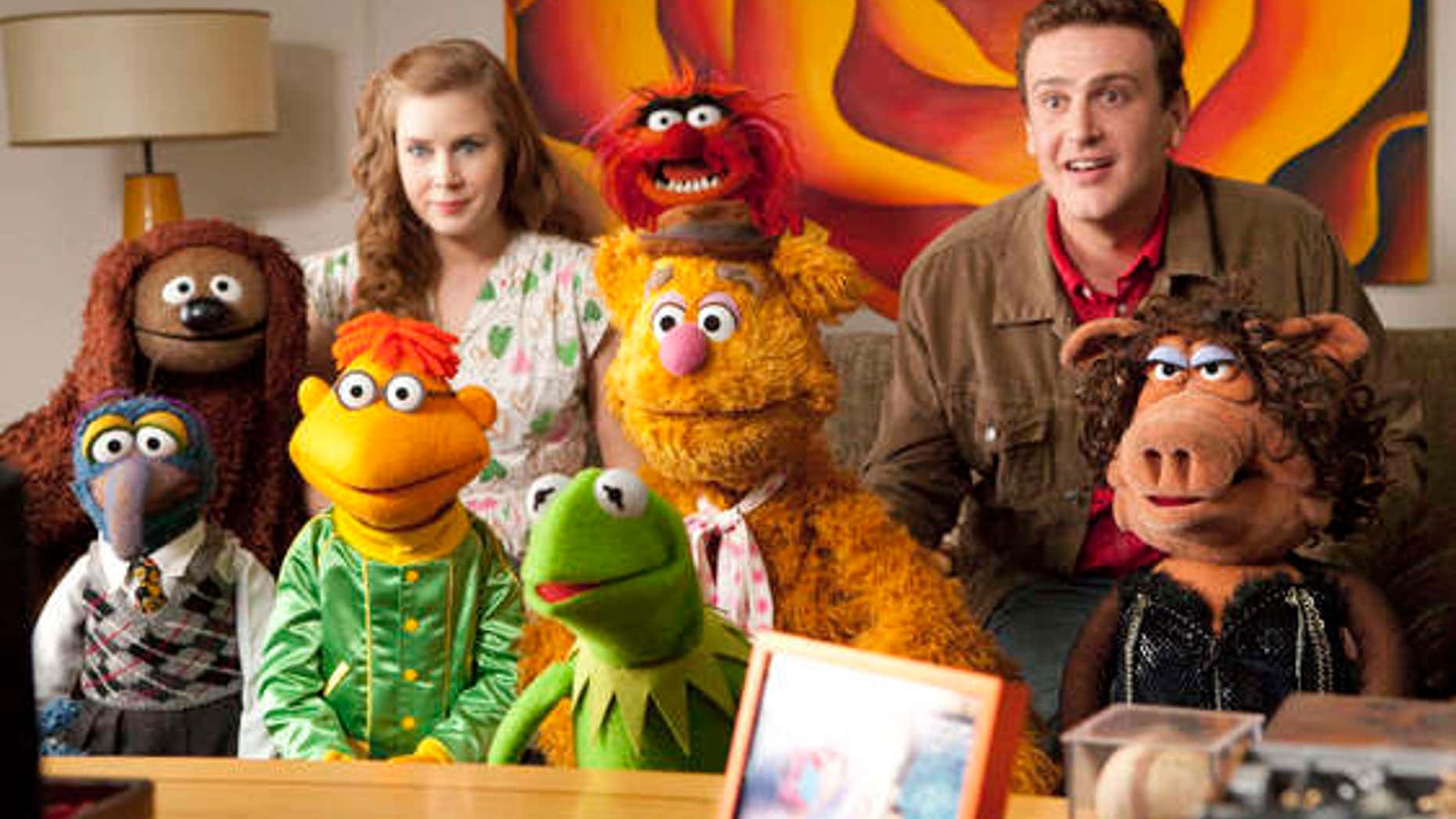 In this film publicity image released by Disney, Amy Adams, left, and Jason Segel are shown with the muppet characters in a scene from "The Muppets." (AP Photo/Disney Enterprises, Patrick Wymore)