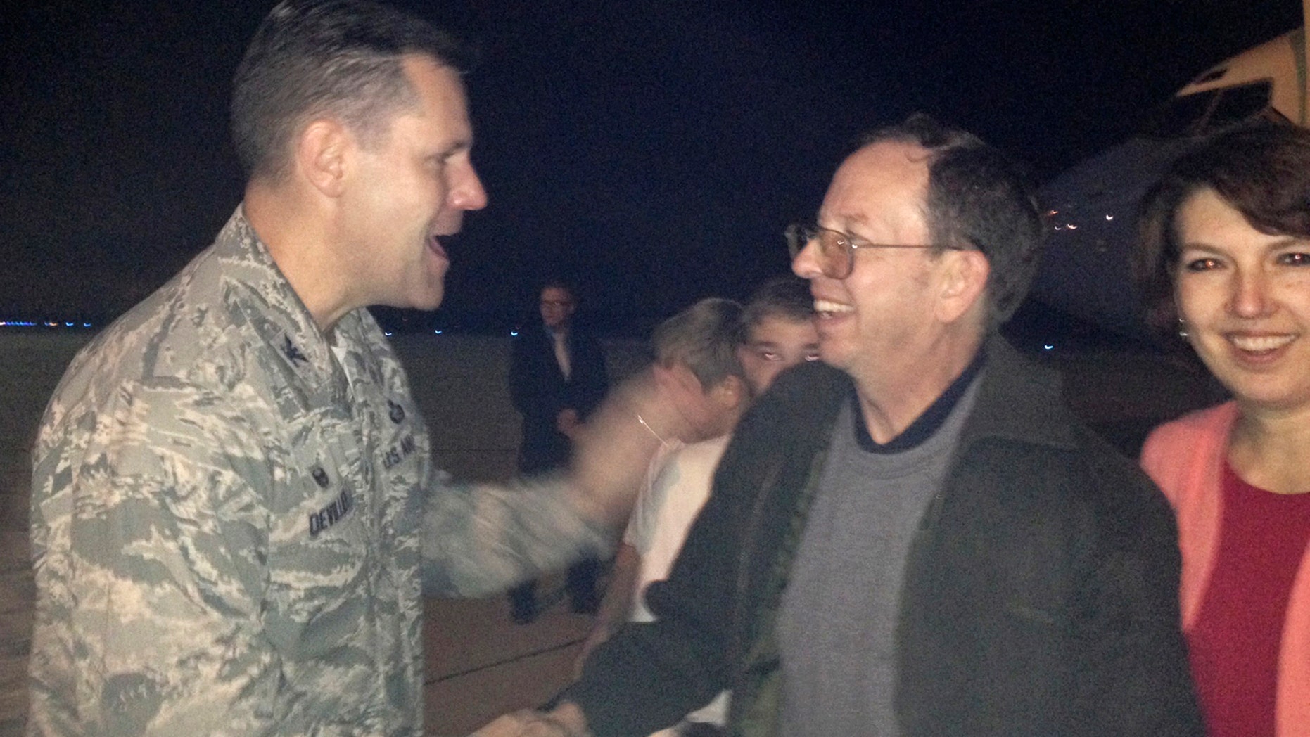 Jeffrey Fowle, (center), and his wife Tatyana were greeted by Air Force Col. John Devillier upon Fowle's arrival on American soil, on Oct. 22, 2014.