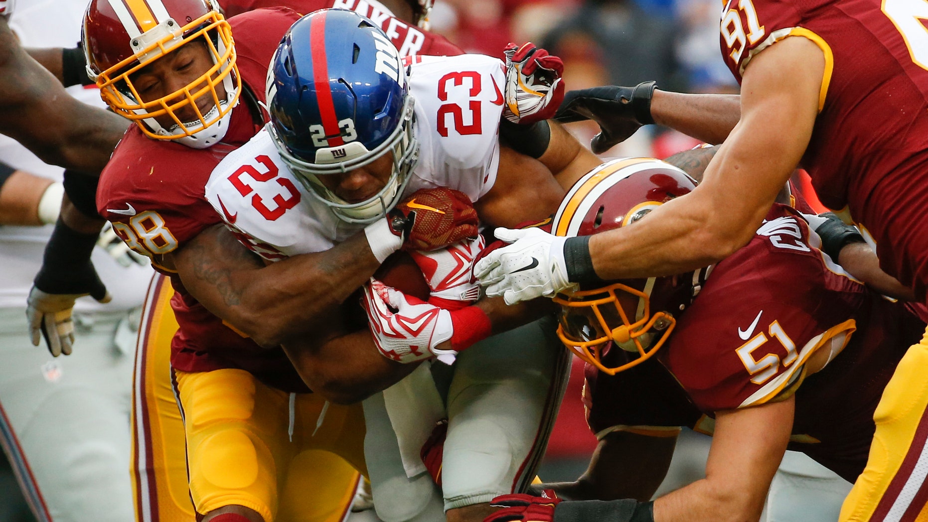 New York Giants running back Rashad Jennings (23) is stopped by Washington Redskins free safety Dashon Goldson (38) and inside linebacker Will Compton (51) during the first half of an NFL football game in Landover, Md., Sunday, Nov. 29, 2015. (AP Photo/Alex Brandon)