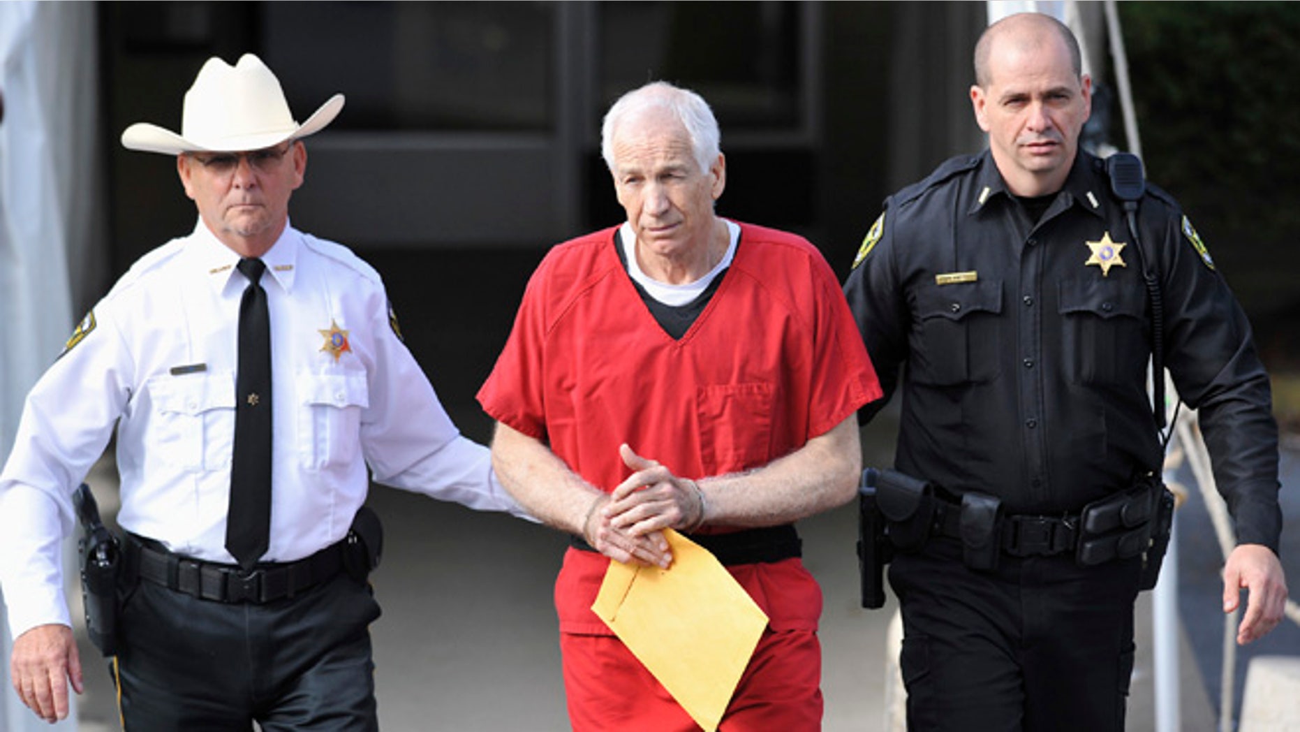 Oct. 9, 2012: Jerry Sandusky, center, leaves the Centre County Courthouse after his sentencing in his child sex abuse case in Bellefonte, Pa.