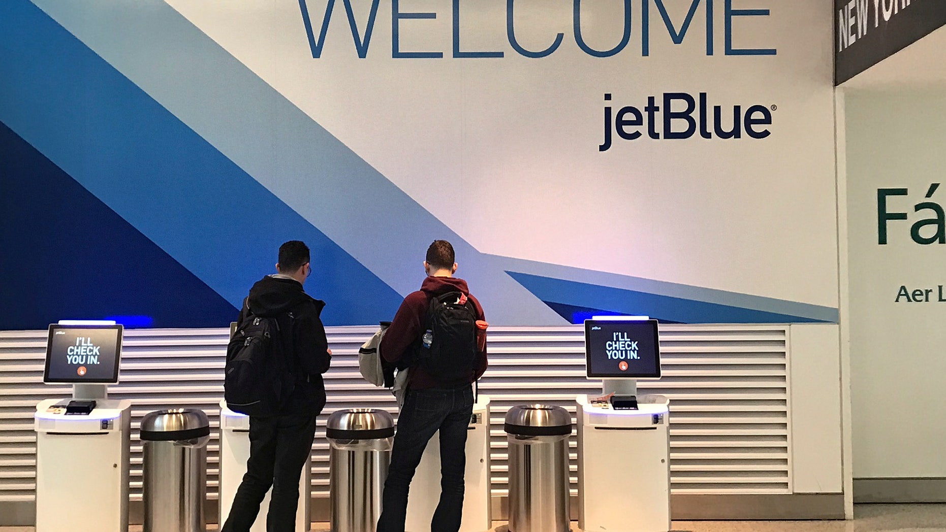 Travelers check-in at a JetBlue Airways kiosk at John F. Kennedy Airport in the Queens borough of New York, U.S., January 24, 2017.