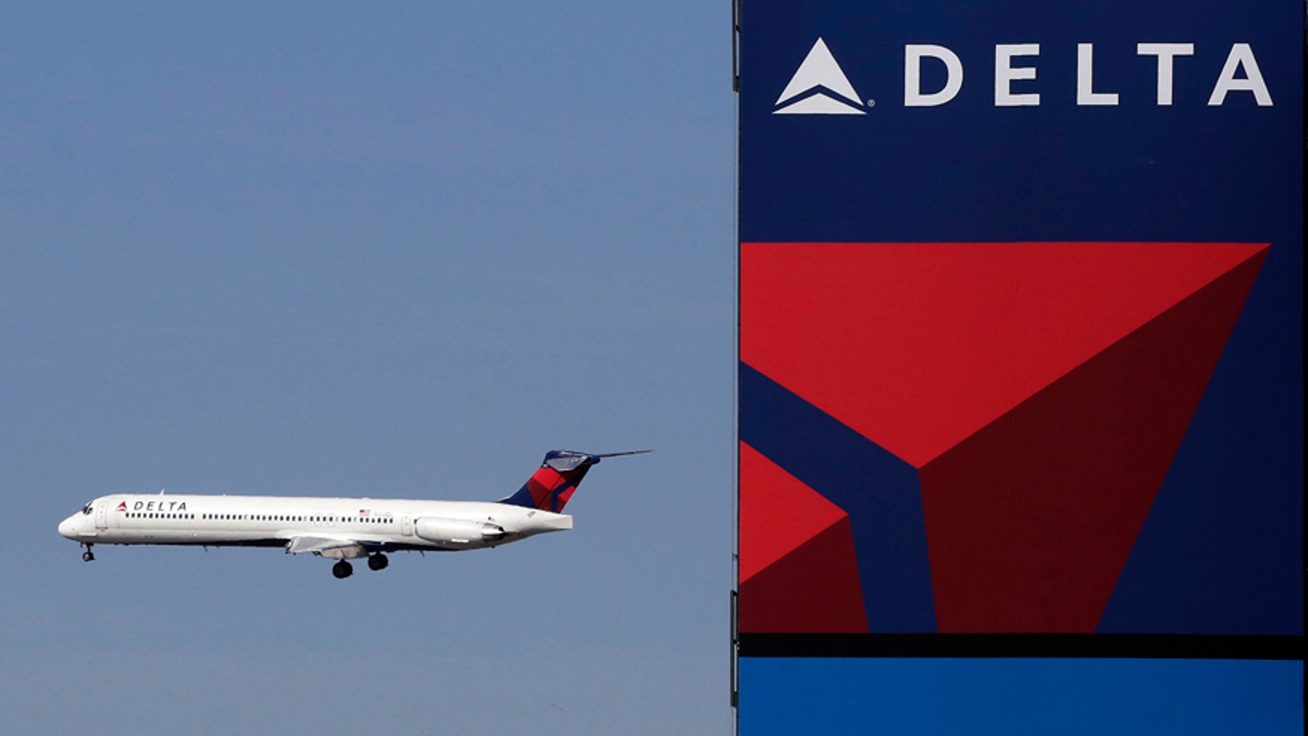 FILE - In this Saturday, April 6, 2013, file photo, a Delta Airlines jet flies past the company's billboard at Citi Field, in New York.