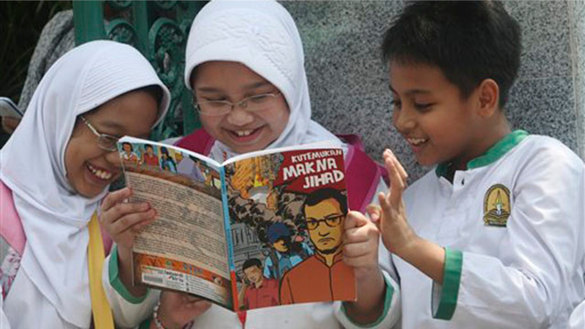 Students read a comic book with an anti-extremist theme at a primary school Friday, Sept. 9, 2011 in Jakarta, Indonesia.