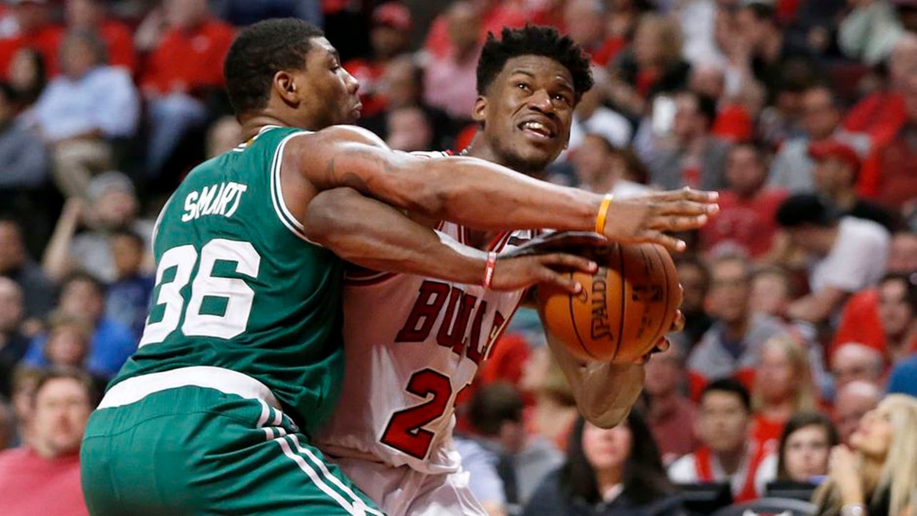 Chicago Bulls' Jimmy Butler (21) is pressured by Boston Celtics' Marcus Smart during the second half in Game 4 of an NBA basketball first-round playoff series in Chicago, Sunday, April 23, 2017. The Celtics won 104-95. (AP Photo/Charles Rex Arbogast)