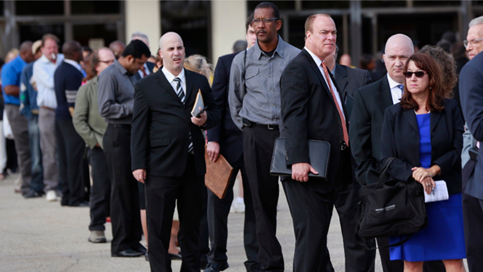 In this Oct. 7, 2014 photo, people wait in line to enter the Nassau County Mega Job Fair at Nassau Veterans Memorial Coliseum in Uniondale, New York.