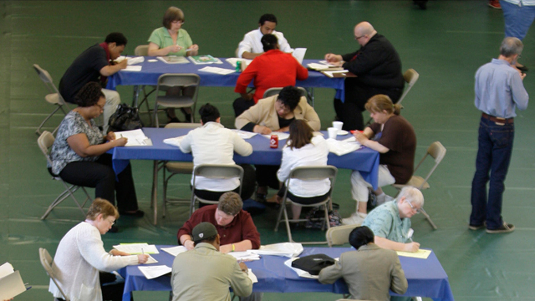 FILE: In this May 25, 2011, photo, people fill out job applications at the Jobapalooza job fair at Lake Erie College, in Painesville, Ohio.