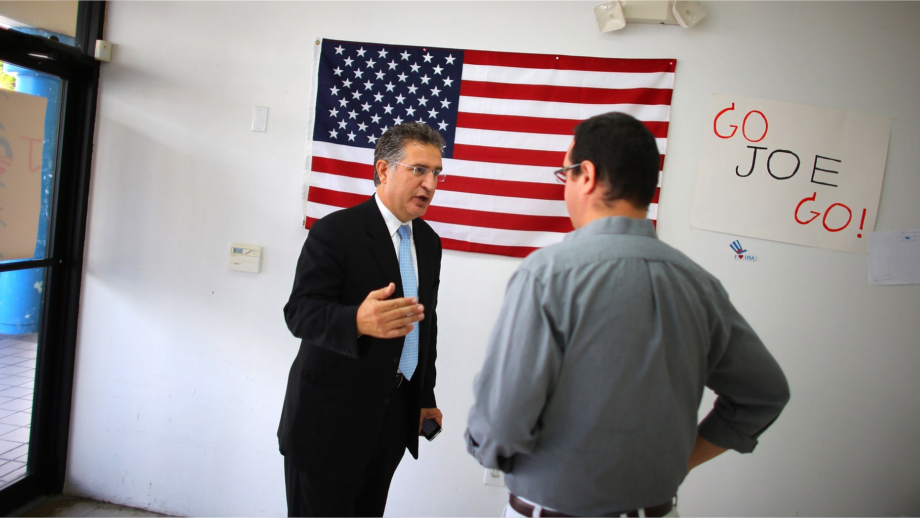 Joe Garcia (L) talks with his campaign manager, John Estes. He defeated opponent Rep. David Rivera (R-FL) in Miami, Florida.