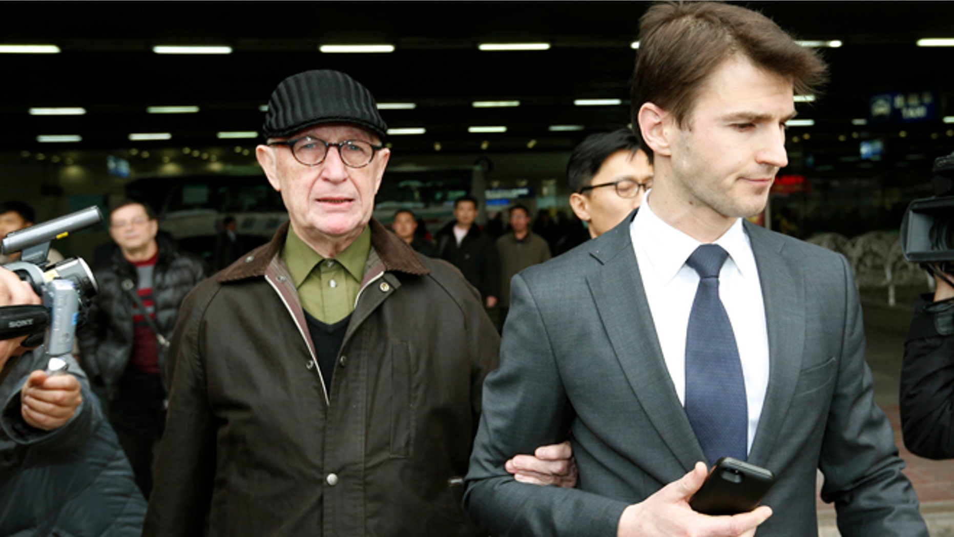 In this March 3, 2014 file photo, Australian missionary John Short, left, walks out from the airport terminal as he arrives at Beijing International Airport in Beijing, China. Short who was detained in North Korea for trying to spread Christianity said Wednesday, March 5, he was interrogated for four hours a day and kept under 24-hour guard during his grueling 13-day investigation.