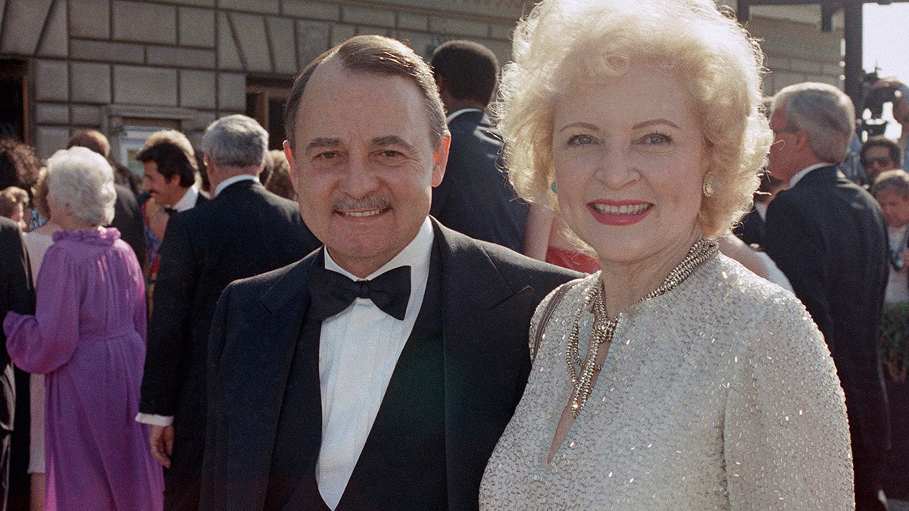 FILE- This Sept. 22, 1985, file photo shows John Hillerman, left, and Betty White, right, arriving at Emmy Awards in Pasadena, Calif. A spokeswoman for the family of Hillerman says the co-star of TVâs âMagnum, P.I.â has died. Hillerman was 84. Spokeswoman Lori De Waal said Hillerman died Thursday at his home in Houston. She said the cause of death has yet to be determined. (AP Photo/LIU, File)