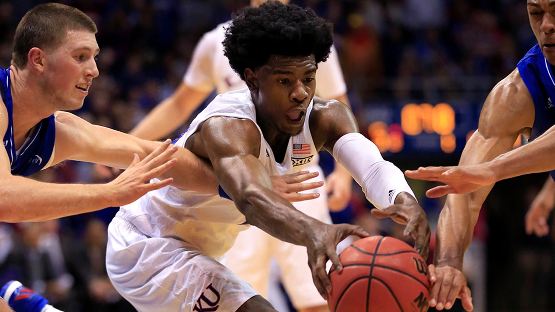 Kansas guard Josh Jackson, center, gets to the ball before UNC-Asheville guards Kevin Vannatta, left, and MaCio Teague, right, during the first half of an NCAA college basketball game in Lawrence, Kan. Nov. 25, 2016