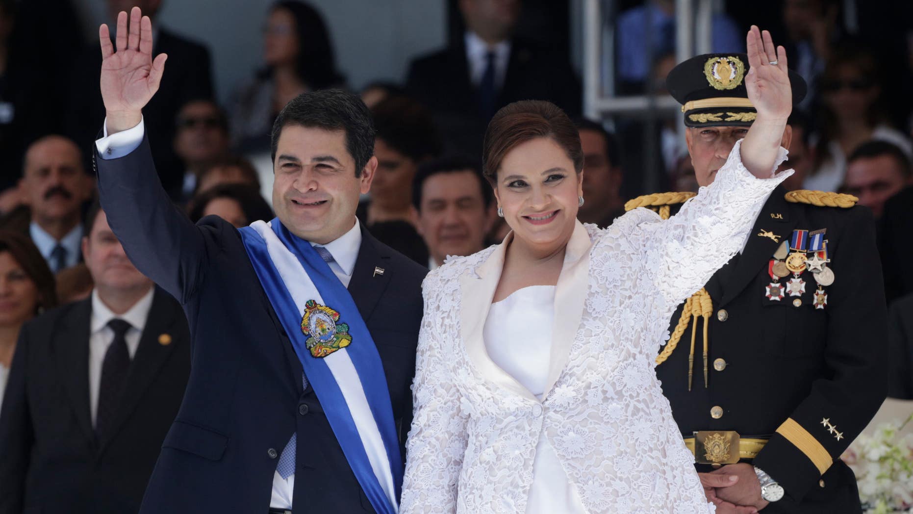 Honduras' President Juan Orlando Hernandez, left, and his wife Ana Rosalinda wave after his swearing in ceremony as new president in Tegucigalpa, Honduras, Monday, Jan. 27, 2014. (AP Photo/Arnulfo Franco)