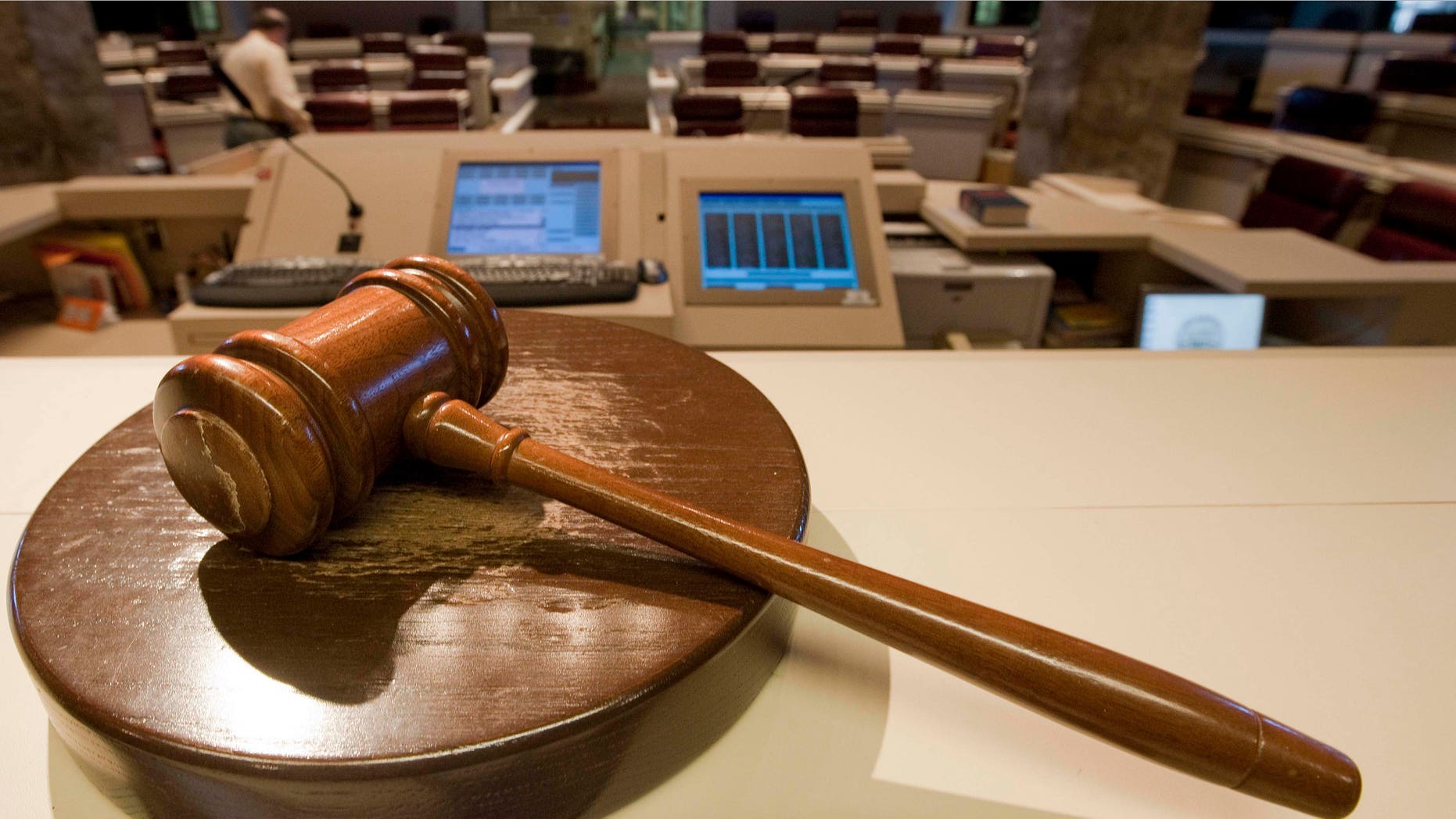 The gavel stands ready as Alabama House Public Information Officer Clay Redden, rear, makes preparations House chamber in Montgomery, Ala., on Friday, Dec. 3, 2010 a for the special session on ethics legislation called by Gov. Bob Riley. The lawmakers come into session next Wednesday. (AP Photo/Dave Martin)