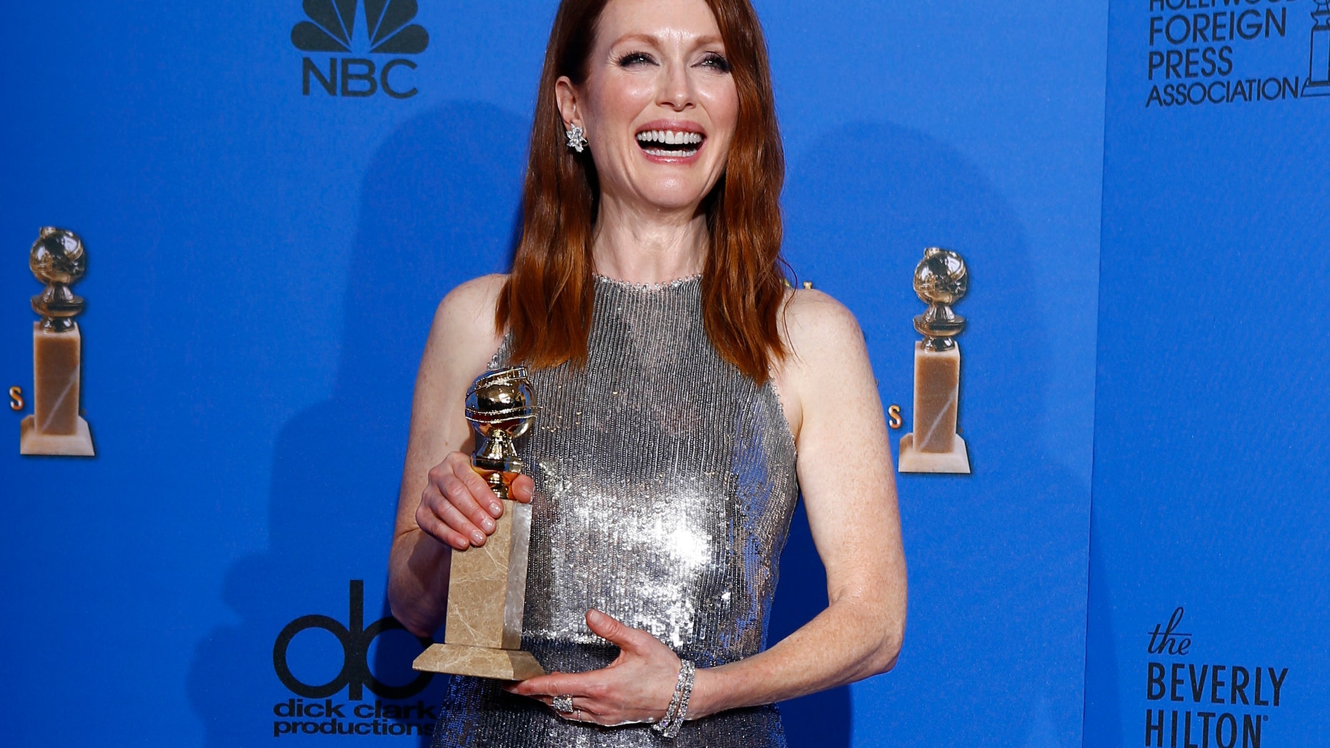Julianne Moore poses with her award for Best Actress in a Motion Picture, Drama for her role in "Still Alice backstage at the 72nd Golden Globe Awards in Beverly Hills, California January 11, 2015. REUTERS/Mike Blake