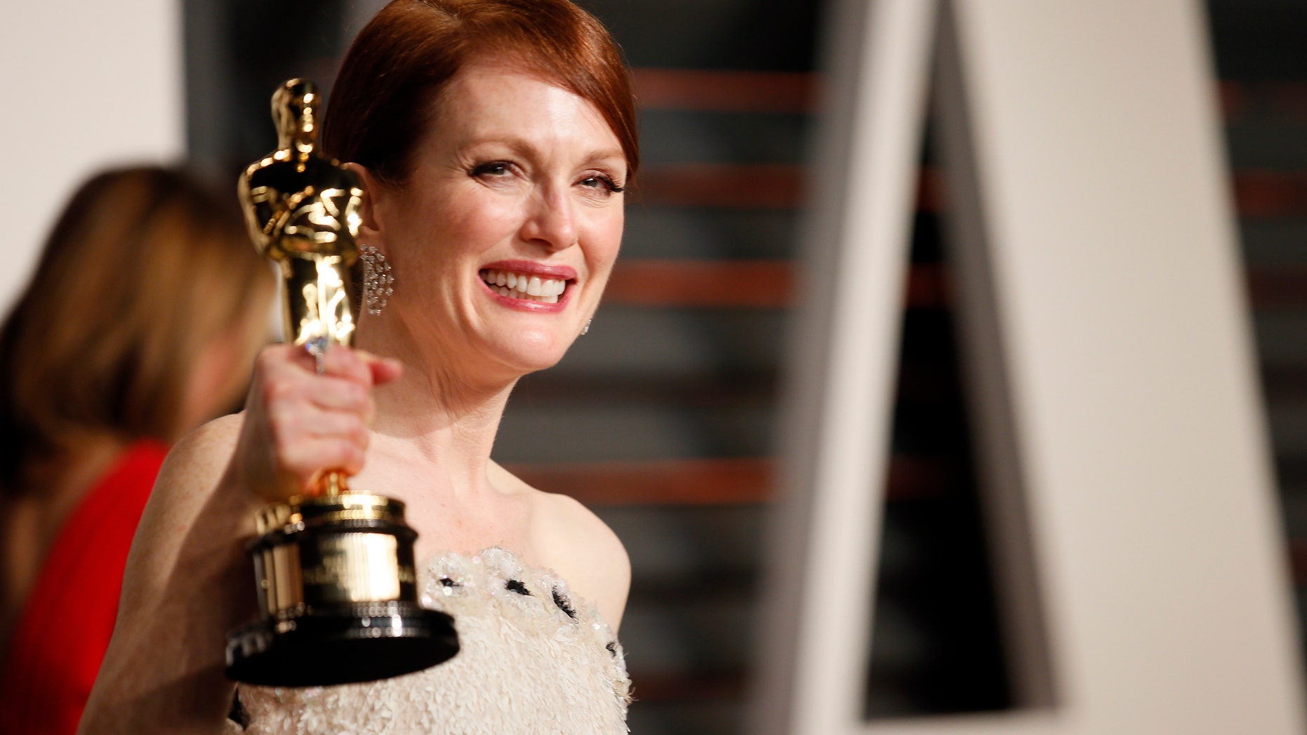 Actress Julianne Moore with her Best Actress award for her role in the film "Still Alice"arrives at the 2015 Vanity Fair Oscar Party in Beverly Hills, California February 22, 2015. REUTERS/Danny Moloshok