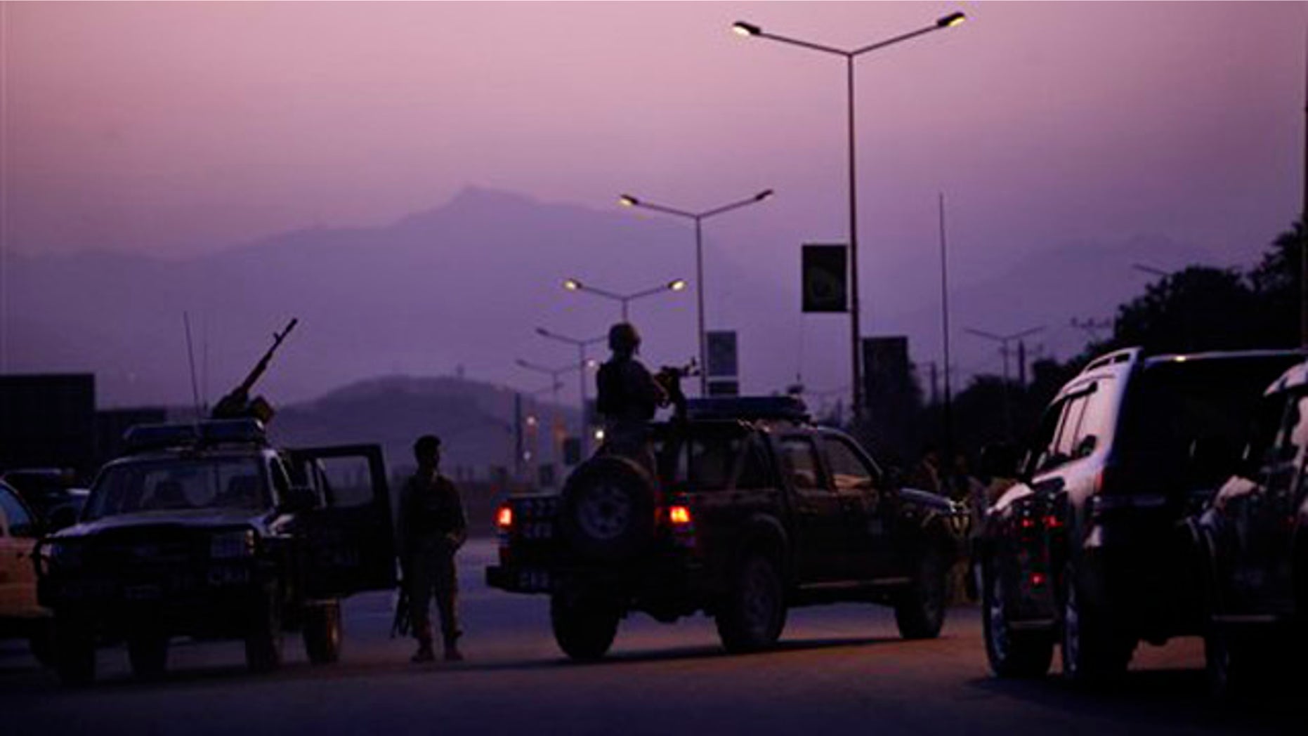 An Afghan army officer mans a heavy gun mounted to a vehicle at the entrance to the InterContinental hotel, which came under attack in Kabul, Afghanistan, June 29.