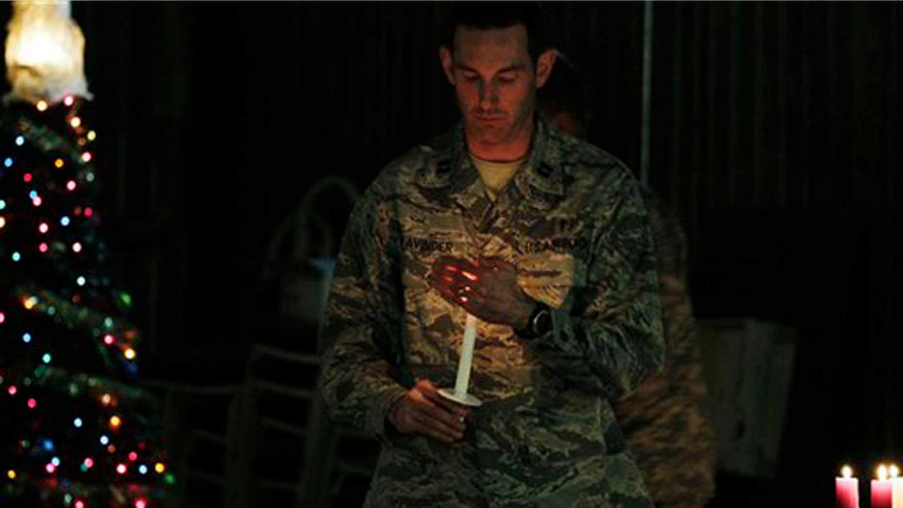 Dec. 24, 2010: A U.S. soldier carries a candle to light those of his colleagues during a ceremony on the eve of Christmas at the U.S. base of Camp Phoenix in Kabul, Afghanistan.