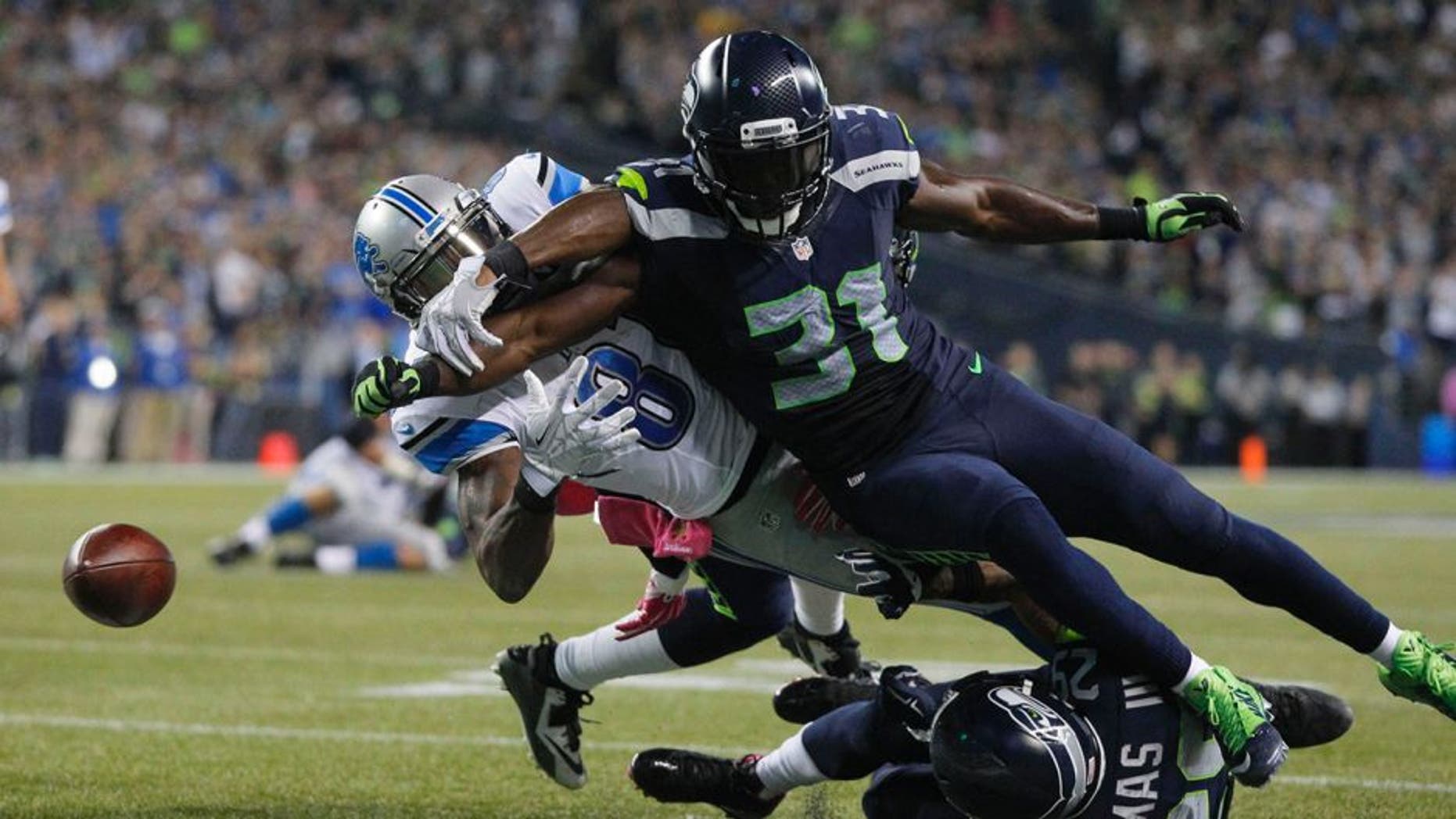 Oct 5, 2015; Seattle, WA, USA; Seattle Seahawks strong safety Kam Chancellor (31) forces a fumble by Detroit Lions wide receiver Calvin Johnson (81) during the fourth quarter at CenturyLink Field. Mandatory Credit: Joe Nicholson-USA TODAY Sports