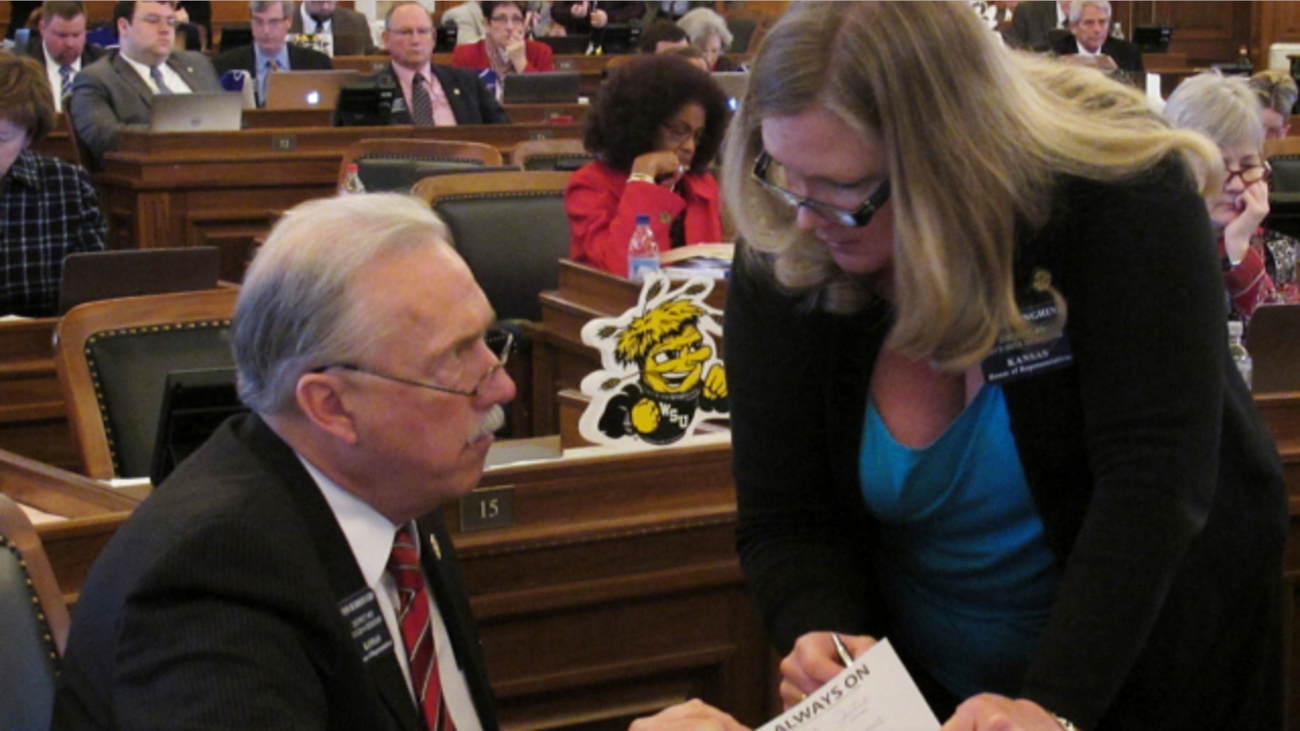 March 19, 2013: Kansas state Rep. Tom Burroughs, left, consults with Rep. Julie Menghini, of Pittsburg, during the House's debate on anti-abortion legislation at the Statehouse in Topeka, Kan.