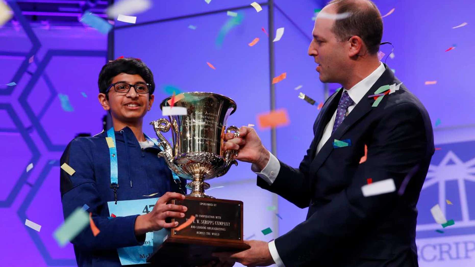 Karthik Nemmani, 14, from McKinney, Texas, holds the Scripps National Spelling Bee Championship Trophy with Scripps President and Chief Executive Officer Adam Symson after winning the Scripps National Spelling Bee in Oxon Hill, Md., May 31, 2018.