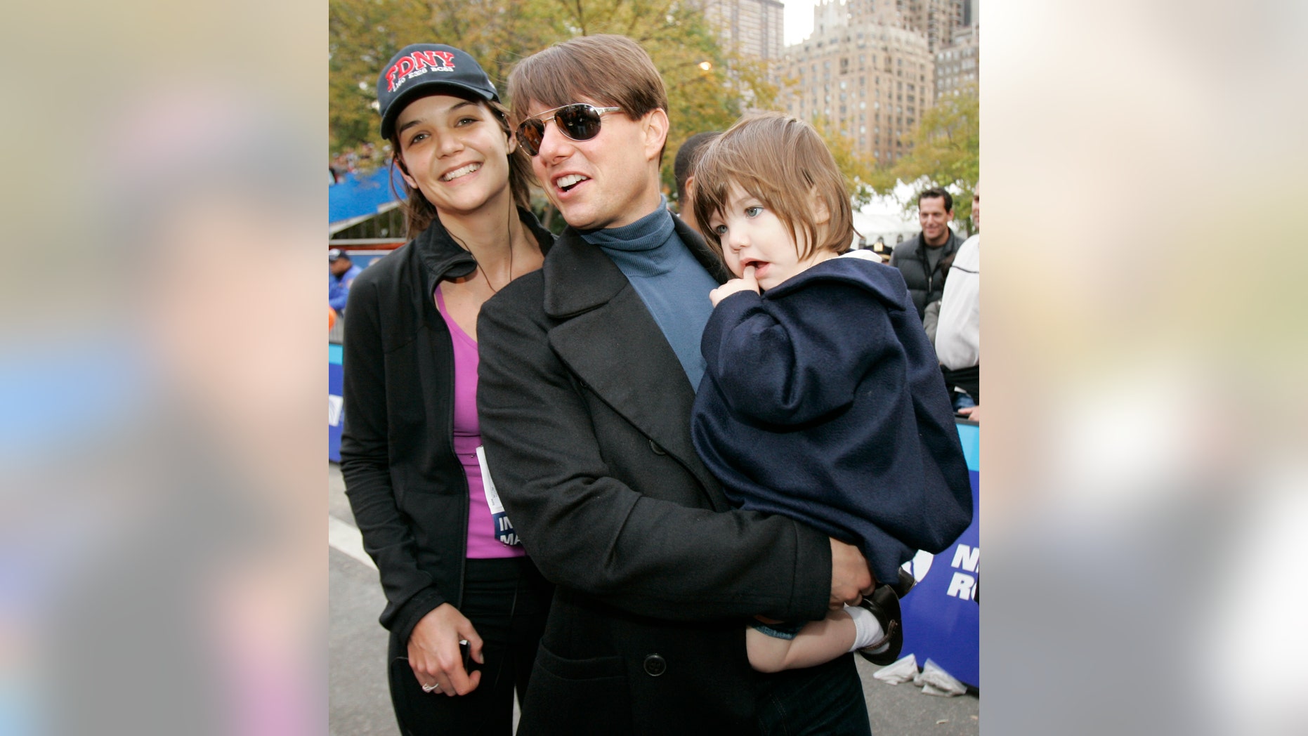 Nov. 4, 2007. Katie Holmes, husband Tom Cruise, center, and their daughter Suri pose for a photograph after Holmes finished running the New York City Marathon in New York. Actress Kristen Bell is leading a movement aimed at reducing the marketplace for paparazzi images of celebrity kids taken without parents consent, and shes using 8-year-old Suri as an example: a child chased by cameras, with no choice in the matter.