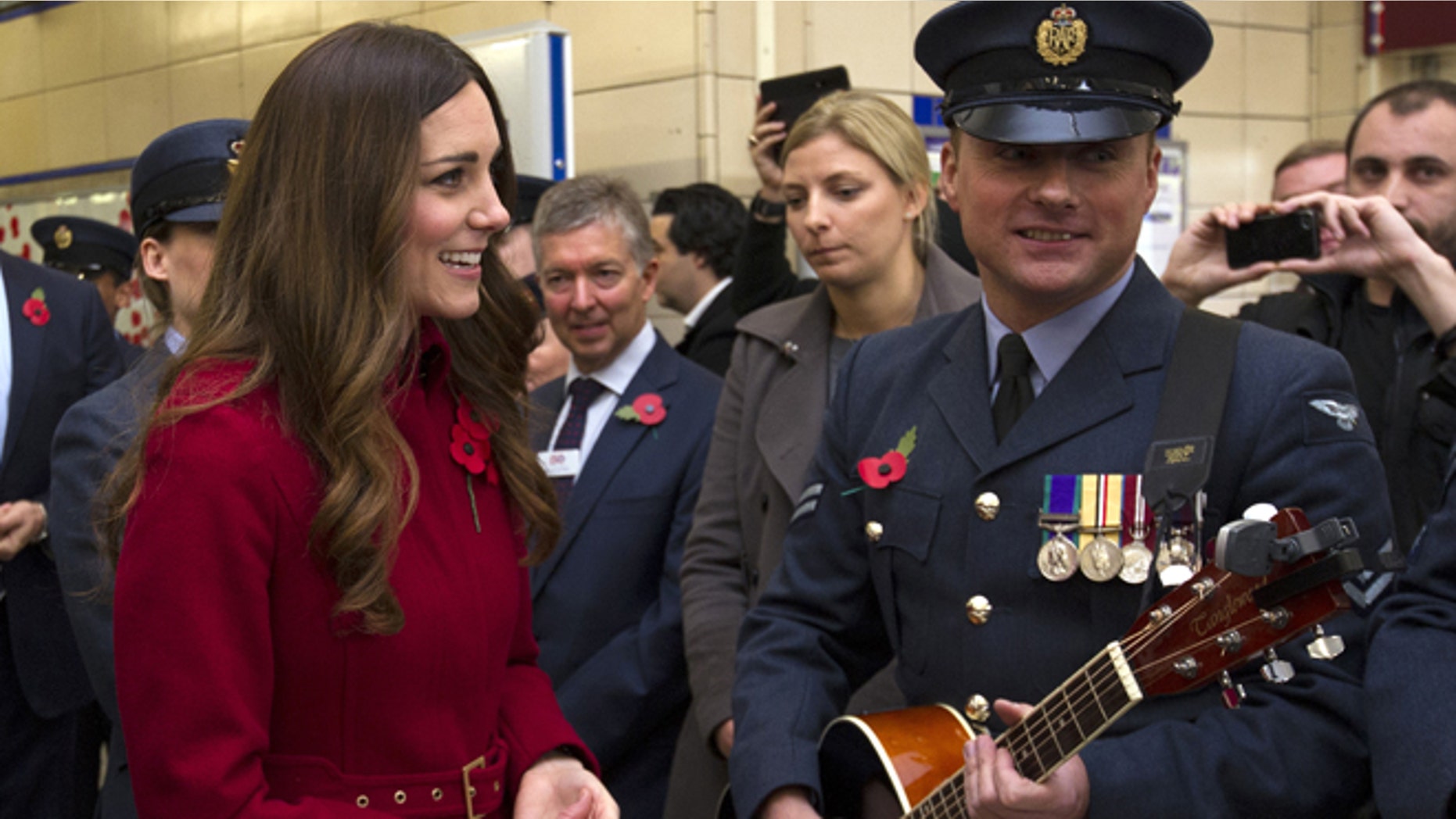 Nov. 7, 2013: Kate, the Duchess of Cambridge, left, reacts with an unidentified member of the Royal British Legion, at Kensington High Street Station, in London.