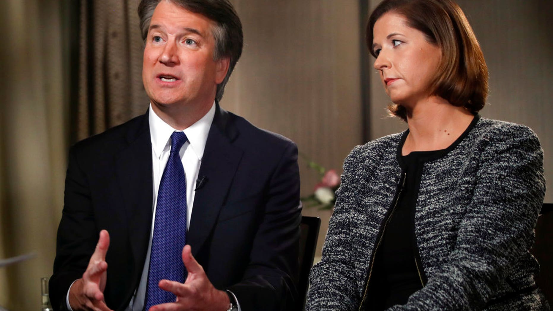 Brett Kavanaugh, with his wife Ashley Estes Kavanaugh, answers questions during a FOX News interview, Monday, Sept. 24, 2018, in Washington, about allegations of sexual misconduct against the Supreme Court nominee. (AP Photo/Jacquelyn Martin)
