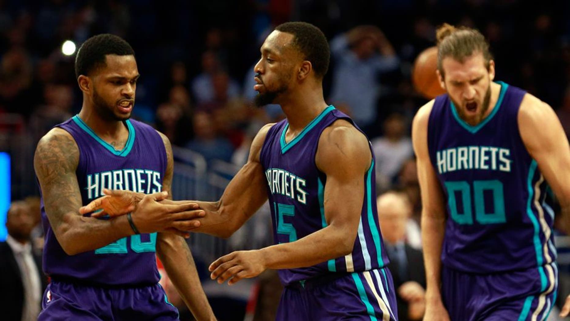 Jan 22, 2016; Orlando, FL, USA; Charlotte Hornets guard Kemba Walker (15) is congratulated by guard Troy Daniels (30) and forward Spencer Hawes (00) during the second half against the Orlando Magic at Amway Center. Charlotte Hornets defeated the Orlando Magic 120-116 in overtime. Mandatory Credit: Kim Klement-USA TODAY Sports