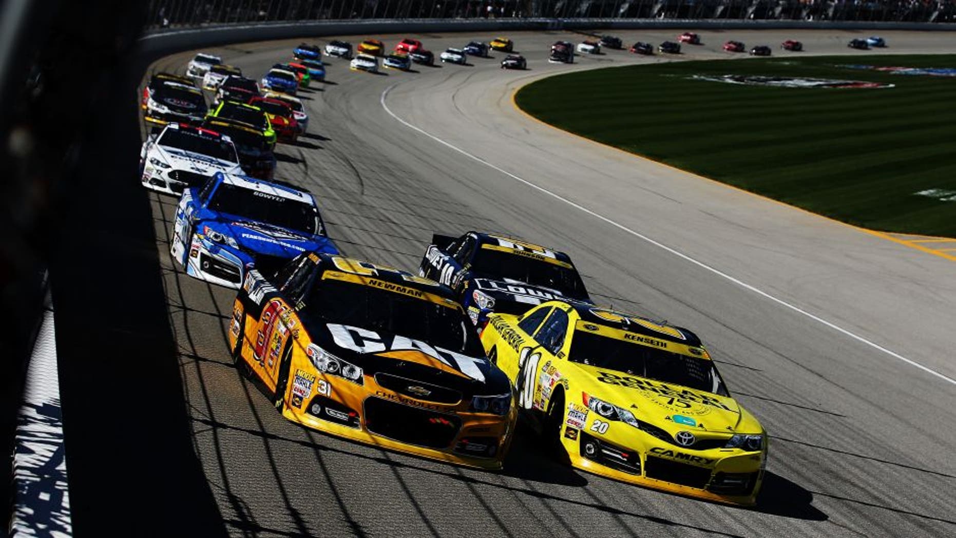 JOLIET, IL - SEPTEMBER 14: Ryan Newman, driver of the #31 Caterpillar Chevrolet, races Matt Kenseth, driver of the #20 Dollar General Toyota, ahead of a pack of cars during the NASCAR Sprint Cup Series MyAFibStory.com 400 at Chicagoland Speedway on September 14, 2014 in Joliet, Illinois. (Photo by Chris Graythen/NASCAR via Getty Images)