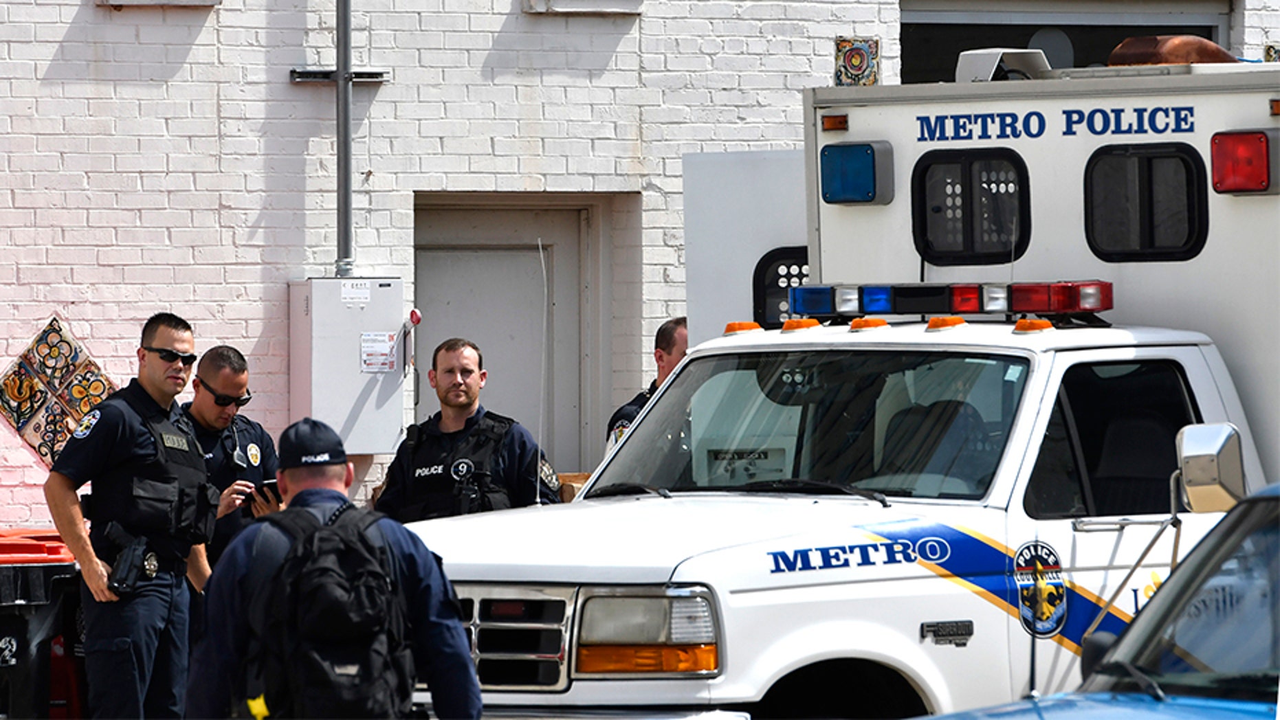 July 26, 2018: Officers with the Louisville Metro Police wait to load members of the Occupy ICE movement into a van at the rear of the Heyburn building.
