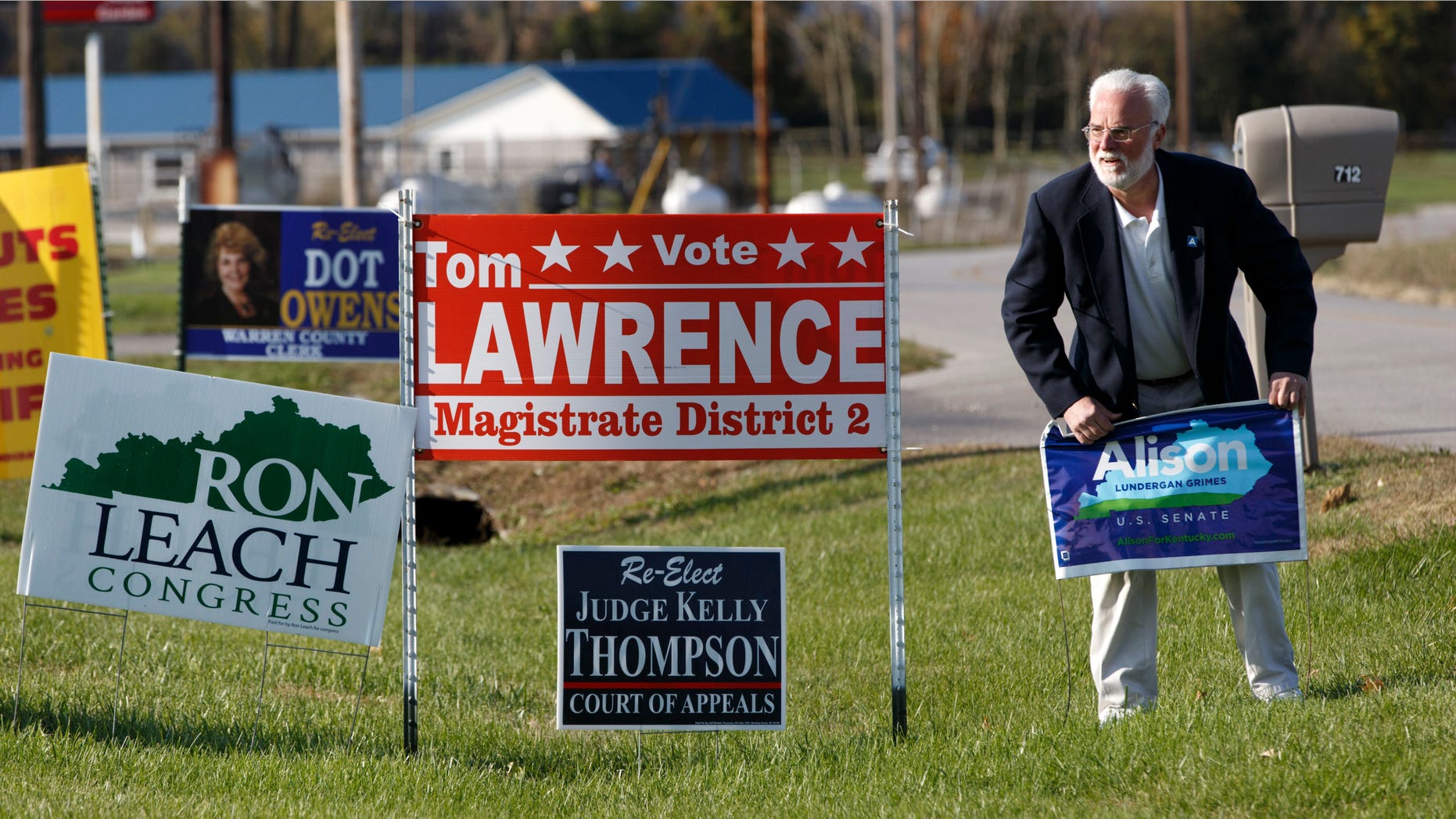 Nov. 3, 2014: Phinis Hundley, a labor organizer for Kentucky Democratic Senate candidate Alison Lundergan Grimes puts out a campaign sign in front of the United Auto Workers hall.