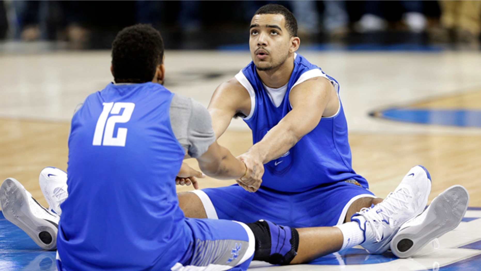 March 25, 2015: Kentucky's Trey Lyles, right, and Karl-Anthony Towns (12) stretch during practice at the NCAA college basketball tournament in Cleveland.