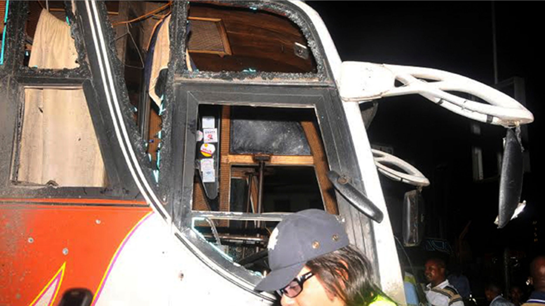 May 3, 2014: People stand near to a bus with windows shattered after an explosion, in Mombasa Kenya