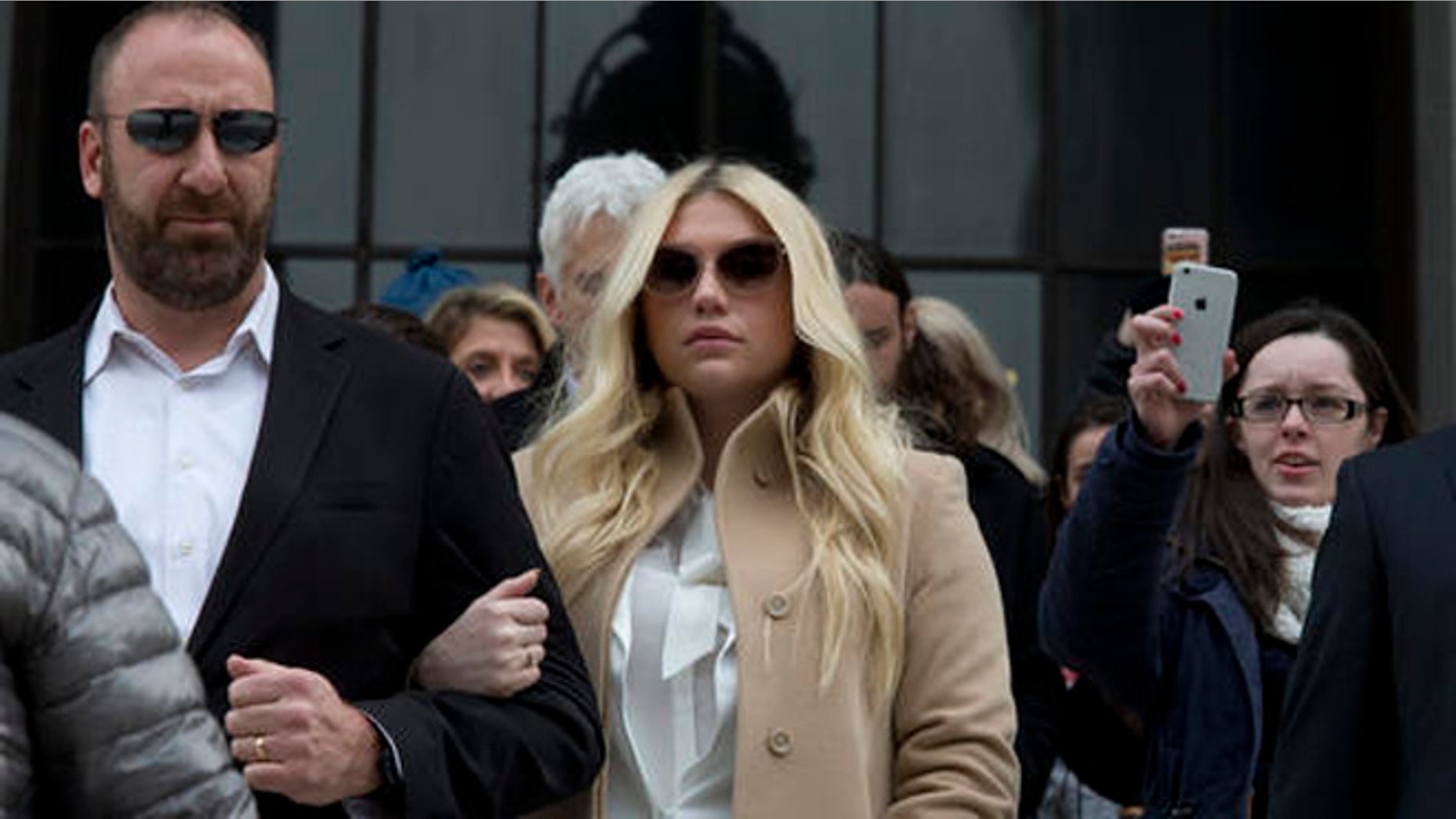 In this Feb. 19, 2016 file photo, pop star Kesha, center, leaves Supreme court in New York.