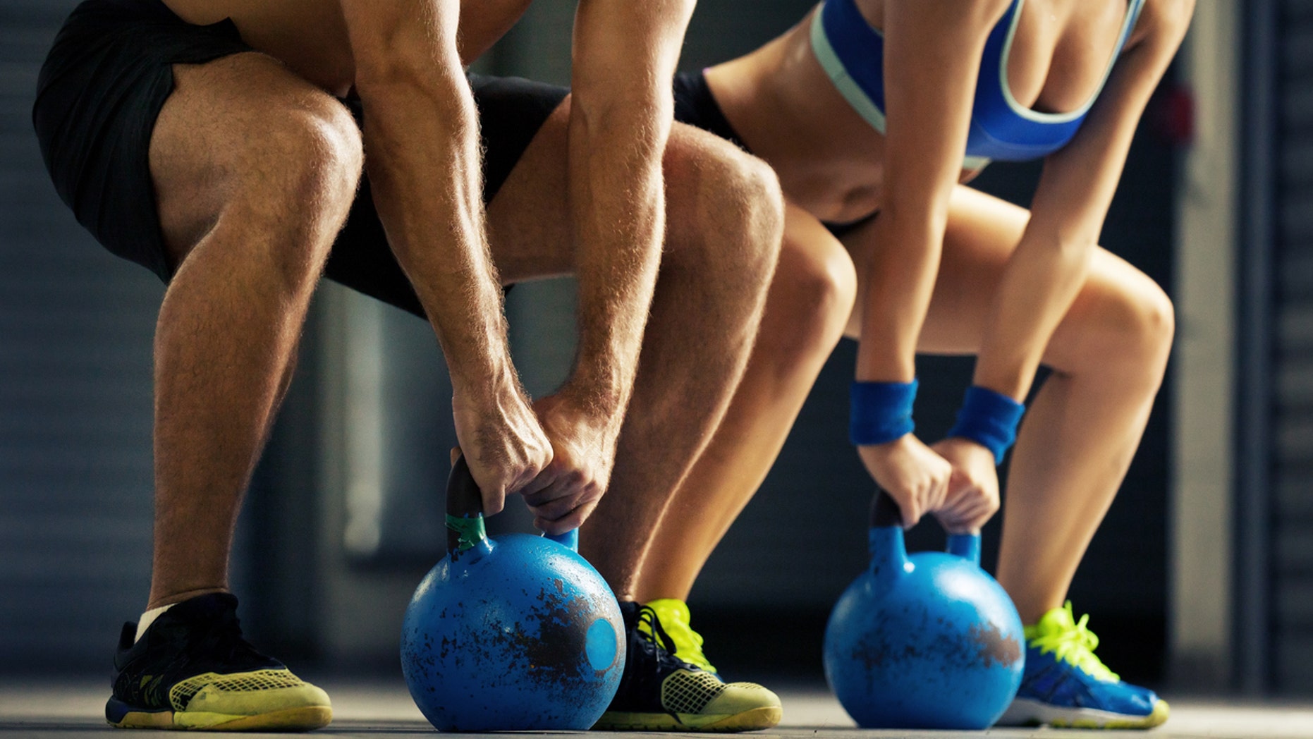 Fit man and woman training by kettlebell.