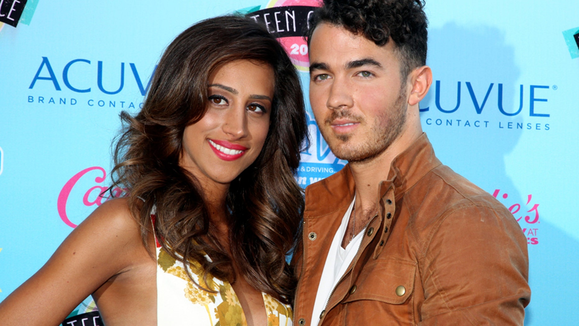 Singer Kevin Jonas and wife Danielle Deleasa pose as they arrive at the Teen Choice Awards at the Gibson amphitheatre in Universal City, California August 11, 2013.