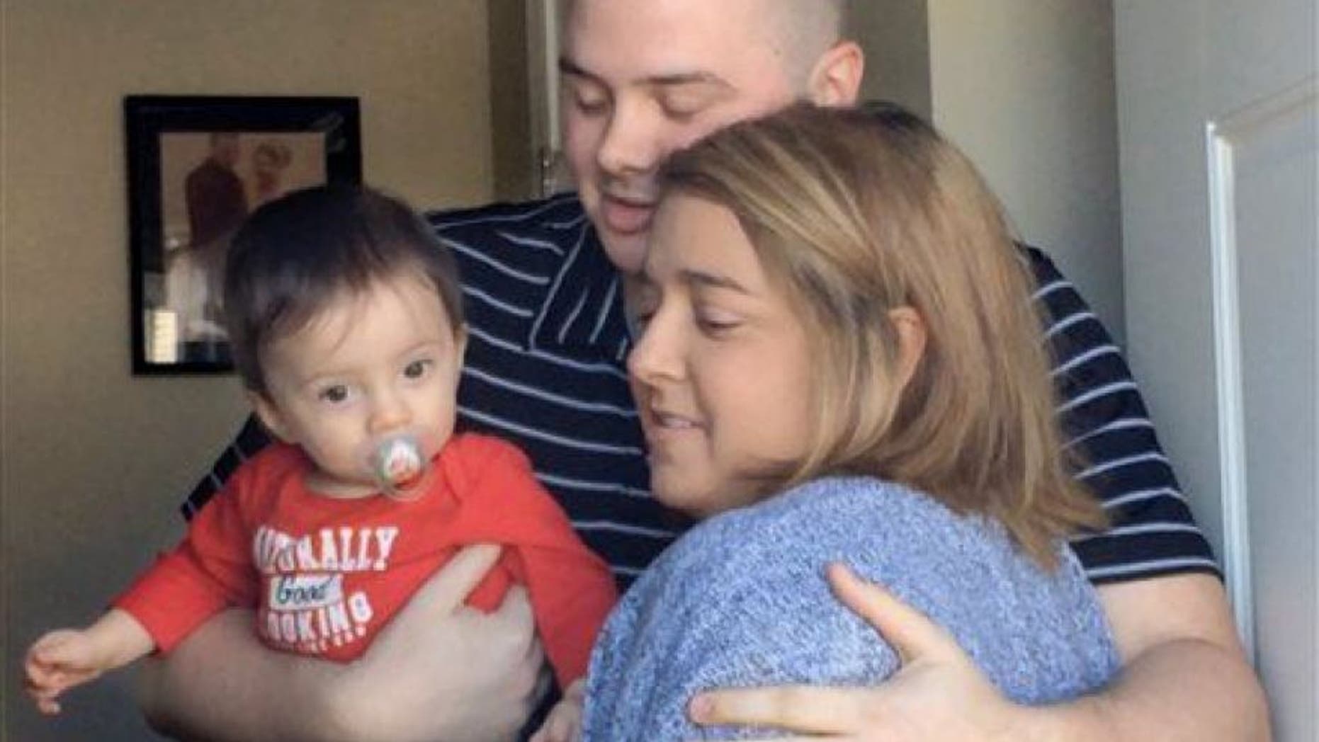 In this Tuesday, March 24, 2015 photo, Josh Dall-Leighton, holding son Christopher, hugs Christine Royles as they meet for the first time, at his home in Windham, Maine. (AP Photo/Portland Press Herald, Susan Kimball)