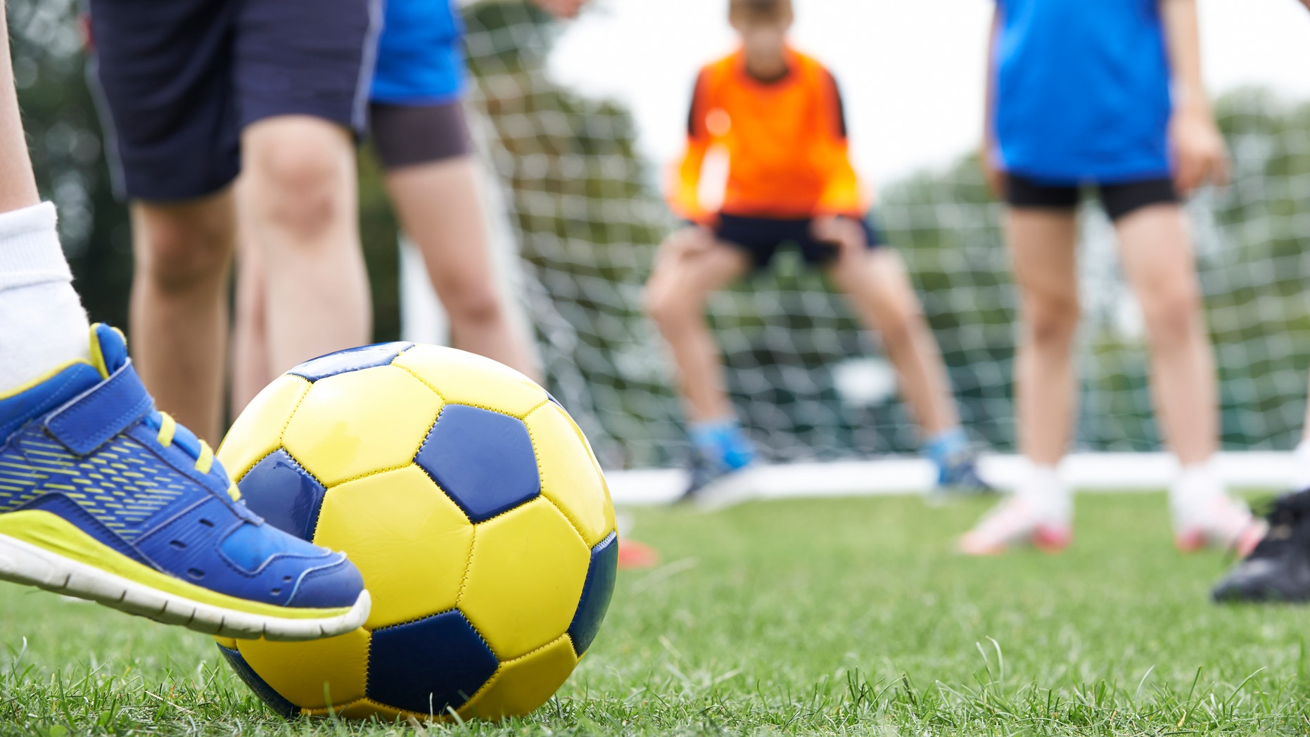 Close Up Of Children's Feet In Soccer Match