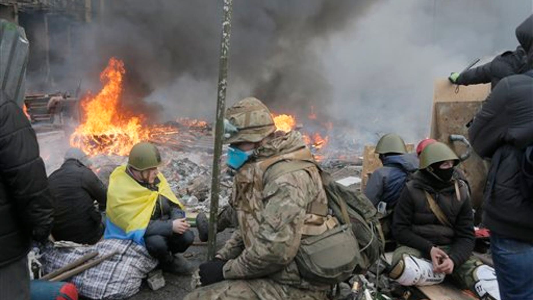 Anti-government protesters relax at the barricades during clashes with riot police in Kiev's Independence Square, the epicenter of the country's current unrest, Kiev, Ukraine, Wednesday, Feb. 19, 2014. The deadly clashes in Ukraines capital have drawn sharp reactions from Washington, generated talk of possible European Union sanctions and led to a Kremlin statement blaming Europe and the West. A roundup of some of the international reactions. (AP Photo/Efrem Lukatsky)