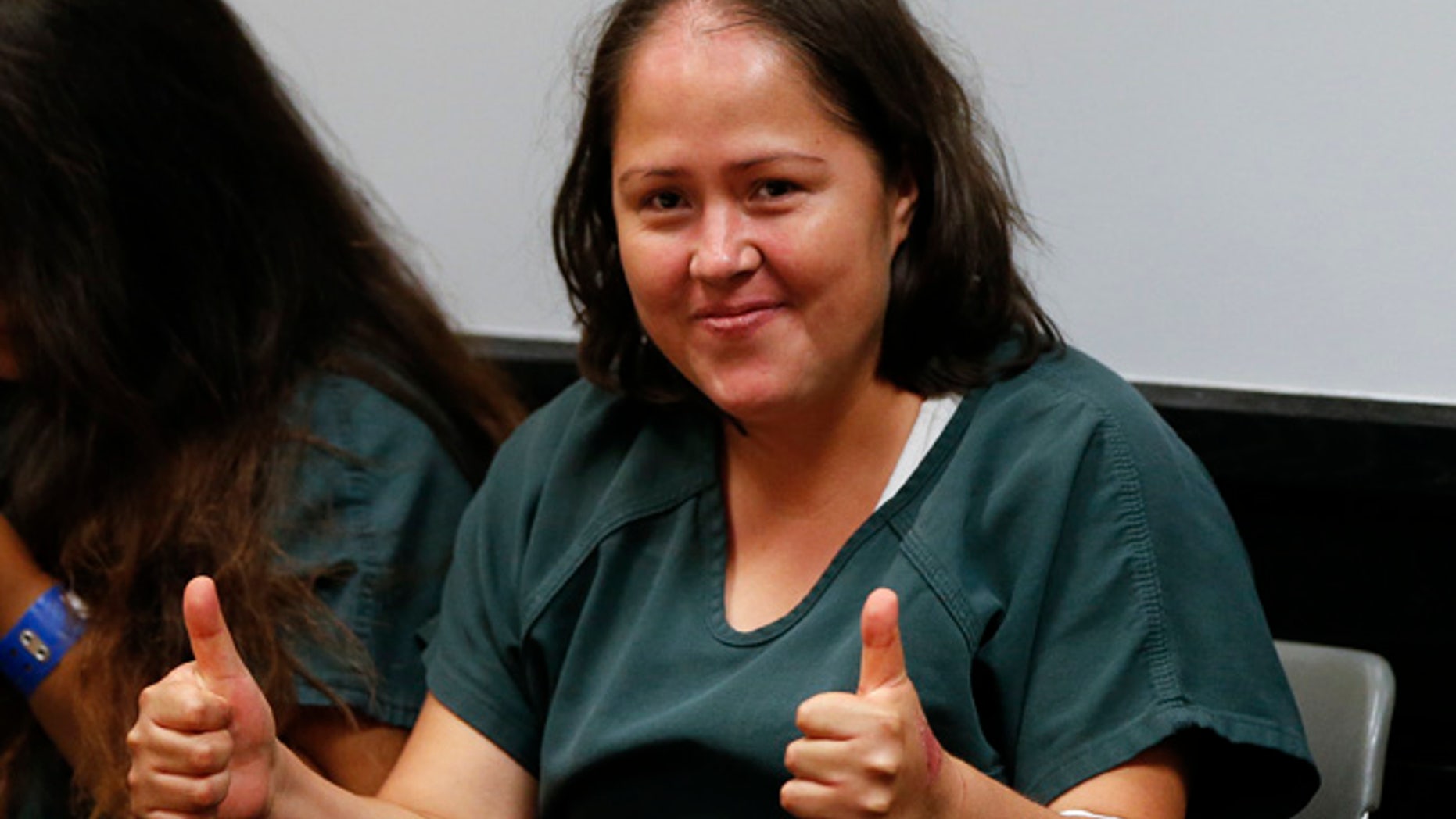 Isabel MartÃnez sonrÃa y hace señales con las manos enfrente de las cámaras el viernes 7 de julio del 2017, durante su primera comparecencia en una corte de Lawrenceville, Georgia. MartÃnez, de 33 años, está acusada de matar a puñaladas a su esposo MartÃn Romero y sus cuatro hijos el 6 de junio. También se le acusa de herir de gravedad a otra menor en su casa en Loganville, comunidad de casas móviles. (AP Foto/John Bazemore)