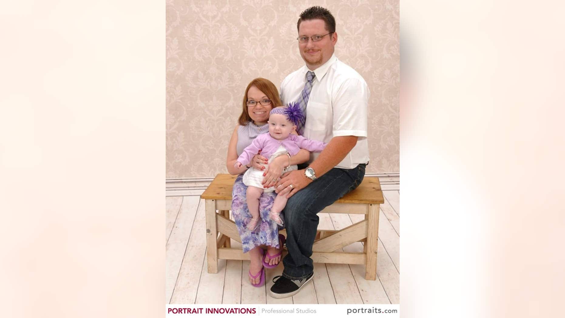 Kimberly Lord poses for a photo with her husband, Adam, and daughter Aubree, now 2.