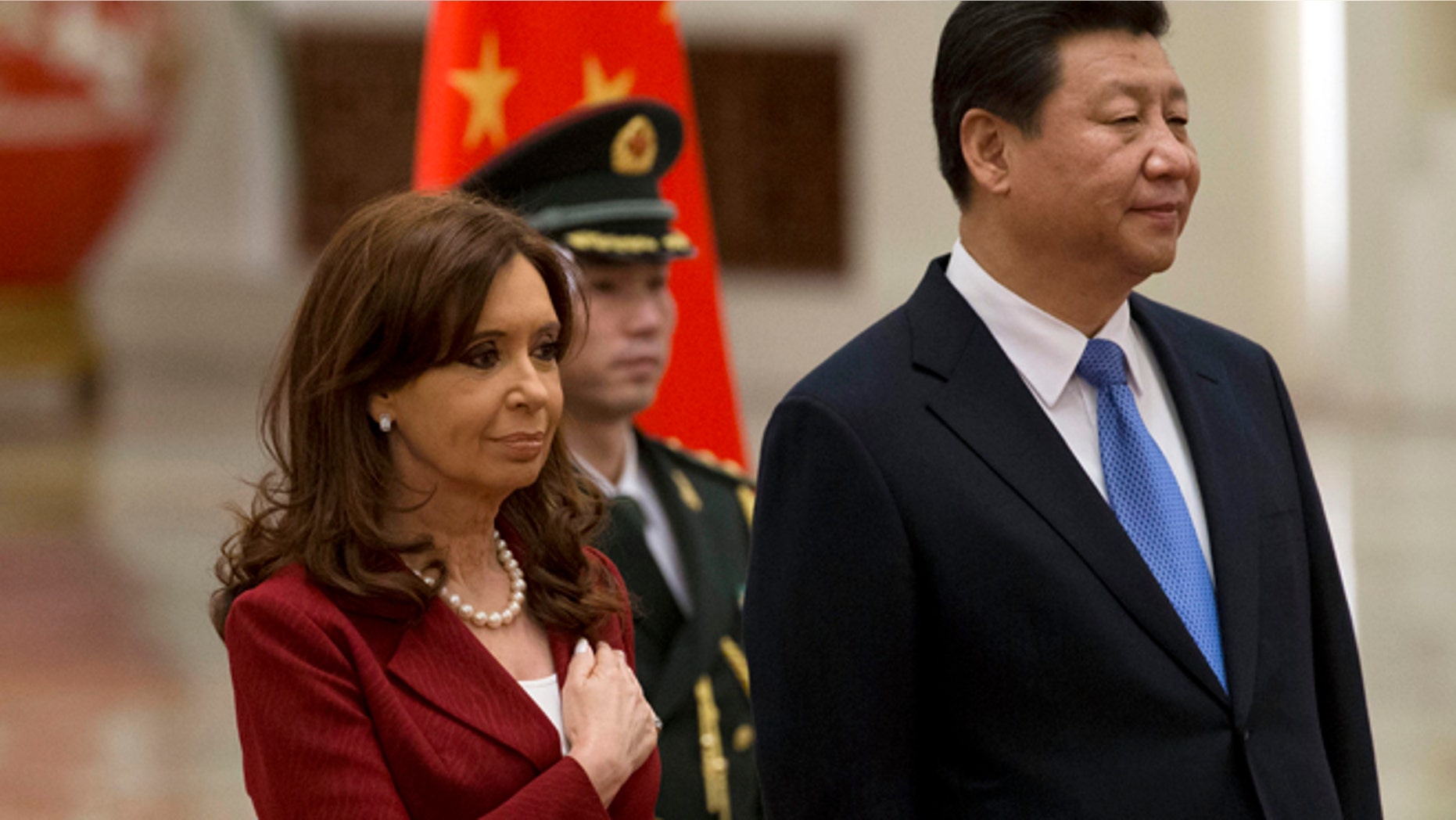 Argentine President Cristina Fernandez places her hand over her chest as she stands next to Chinese President Xi Jinping while the Argentine national anthem is played during a welcome ceremony at the Great Hall of the People in Beijing Wednesday, Feb. 4, 2015. (AP Photo/Ng Han Guan)