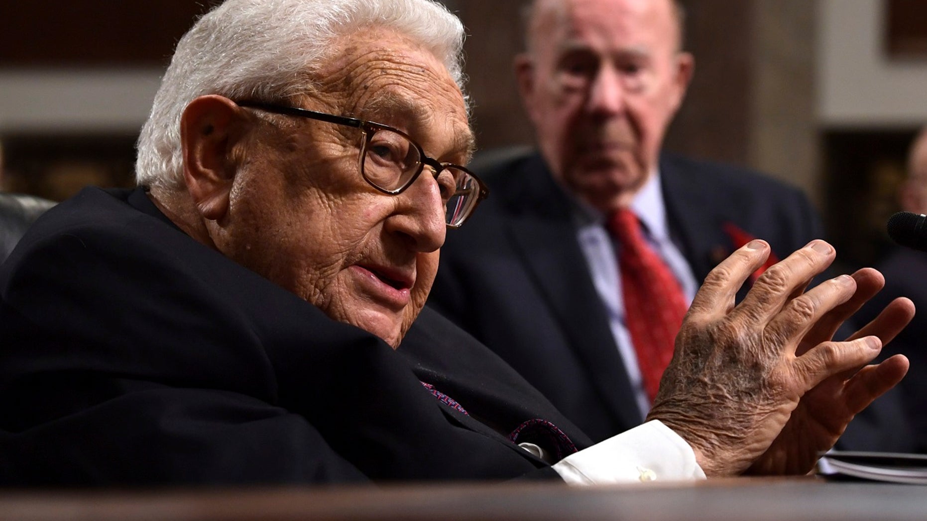 Former U.S. Secretary of State Henry Kissinger, 94, addresses the Senate Armed Services Committee, Jan. 25, 2018, with former U.S. Secretary of State George Shultz, 97, in the background.