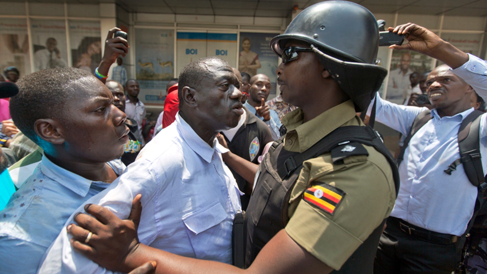 Feb. 15, 2016: Leading opposition leader and presidential candidate Kizza Besigye, center, is grabbed before being arrested by riot police in downtown Kampala, Uganda.