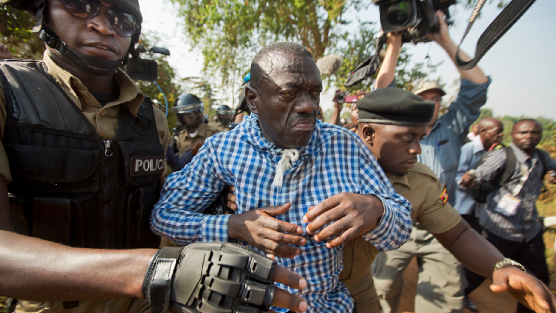 Feb. 22, 2016: Uganda's main opposition leader Kizza Besigye, center, is arrested by police and thrown into the back of a blacked-out police van which whisked him away and was later seen at a rural police station, outside his home in Kasangati, Uganda.