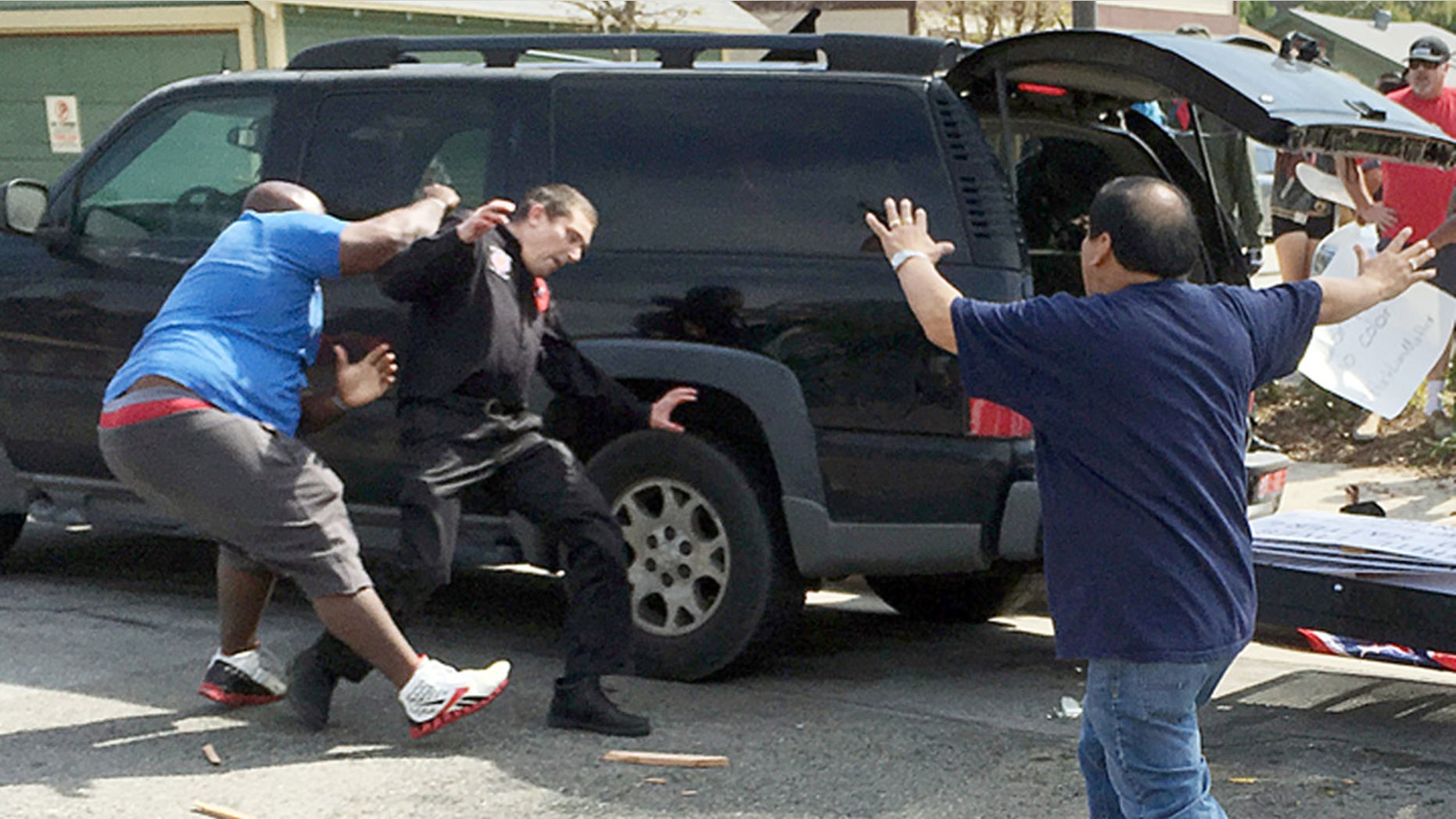 Feb. 27, 2016: A man dressed in Ku Klux Klan garb, center, and a counter-protester, left, confront each other during a KKK rally at Pearson Park in Anaheim, Calif. (AP/B. Levin Center for the Study of Hate & Extremism)