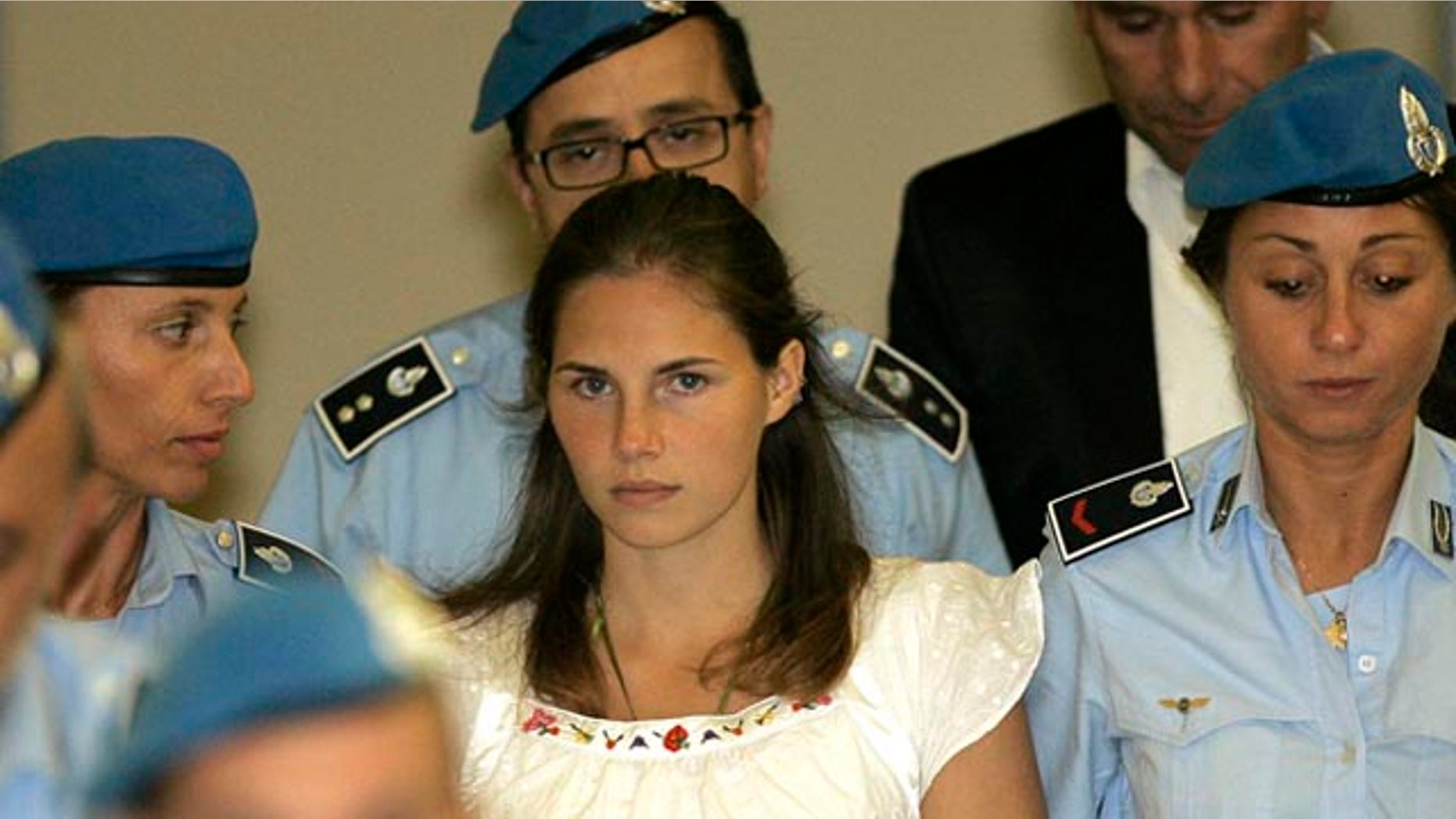 FILE: In this Sept. 16, 2008 photo, U.S. murder suspect Amanda Knox, is escorted by Italian penitentiary police officers from Perugia's court after a hearing in central Italy. After three years in prison, Knox returns to court Nov. 24 for a second chance at freedom.